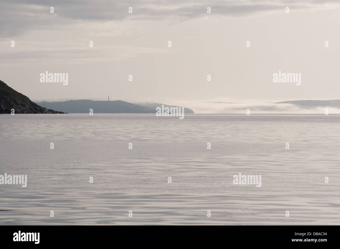 Nebbia di terra il rotolamento lungo il fiume Fowey e sopra il livello del mare. View all'alba da gorran haven. Foto Stock