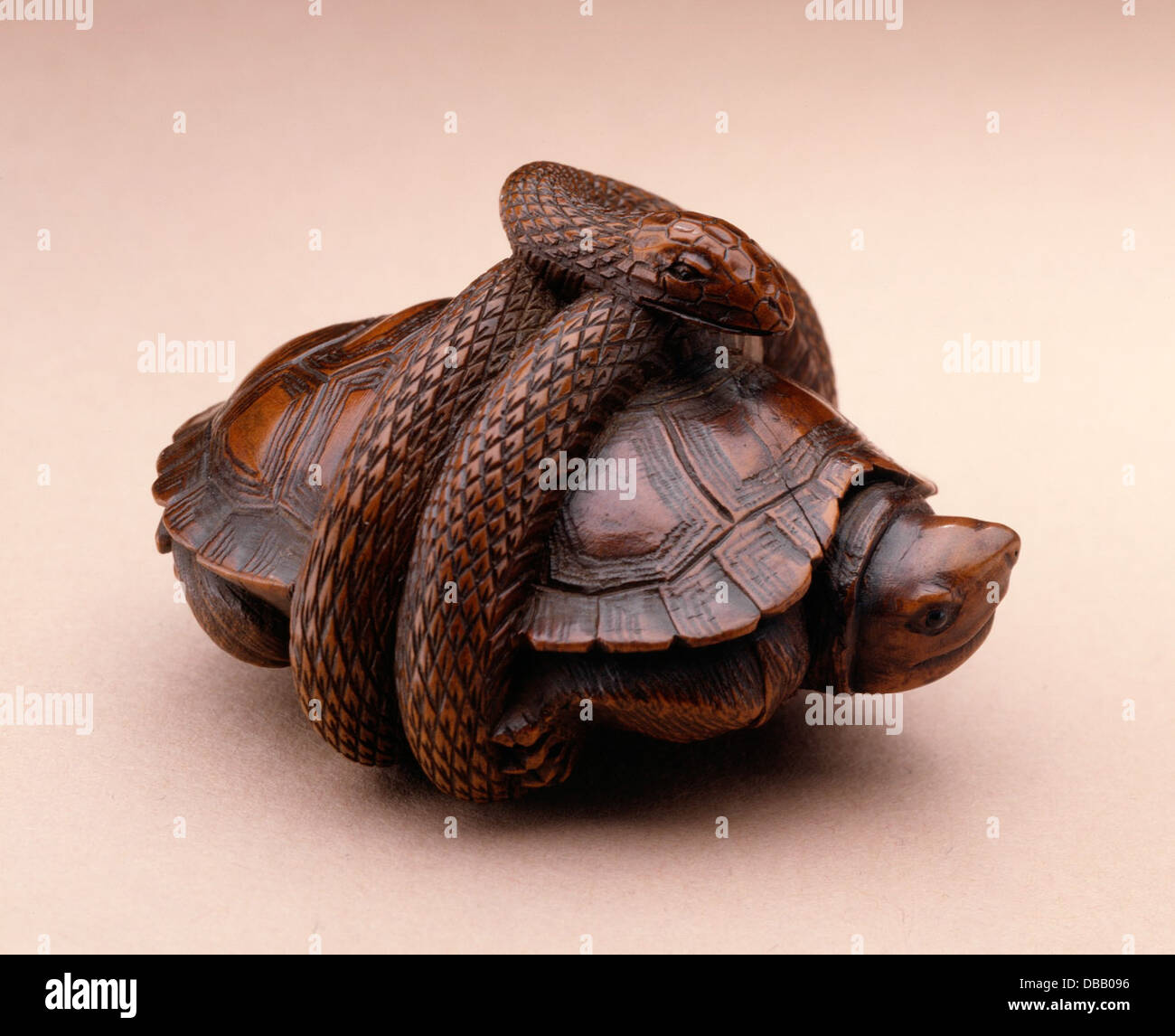 Questa scultura presenta un serpente che circonda una tartaruga, a simboleggiare l'equilibrio tra forze opposte in natura. Il pezzo riflette l'abilità dell'artista nel rendere forme naturalistiche e catturare l'armonia tra i diversi elementi. Foto Stock