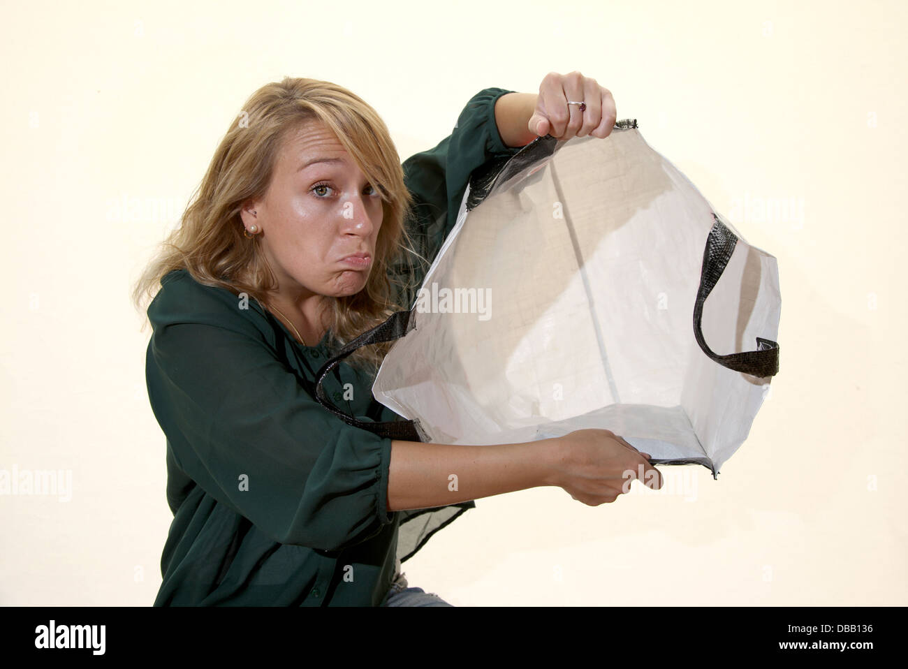 Ragazza bionda sta tenendo un carrello spesa vuoto Foto Stock