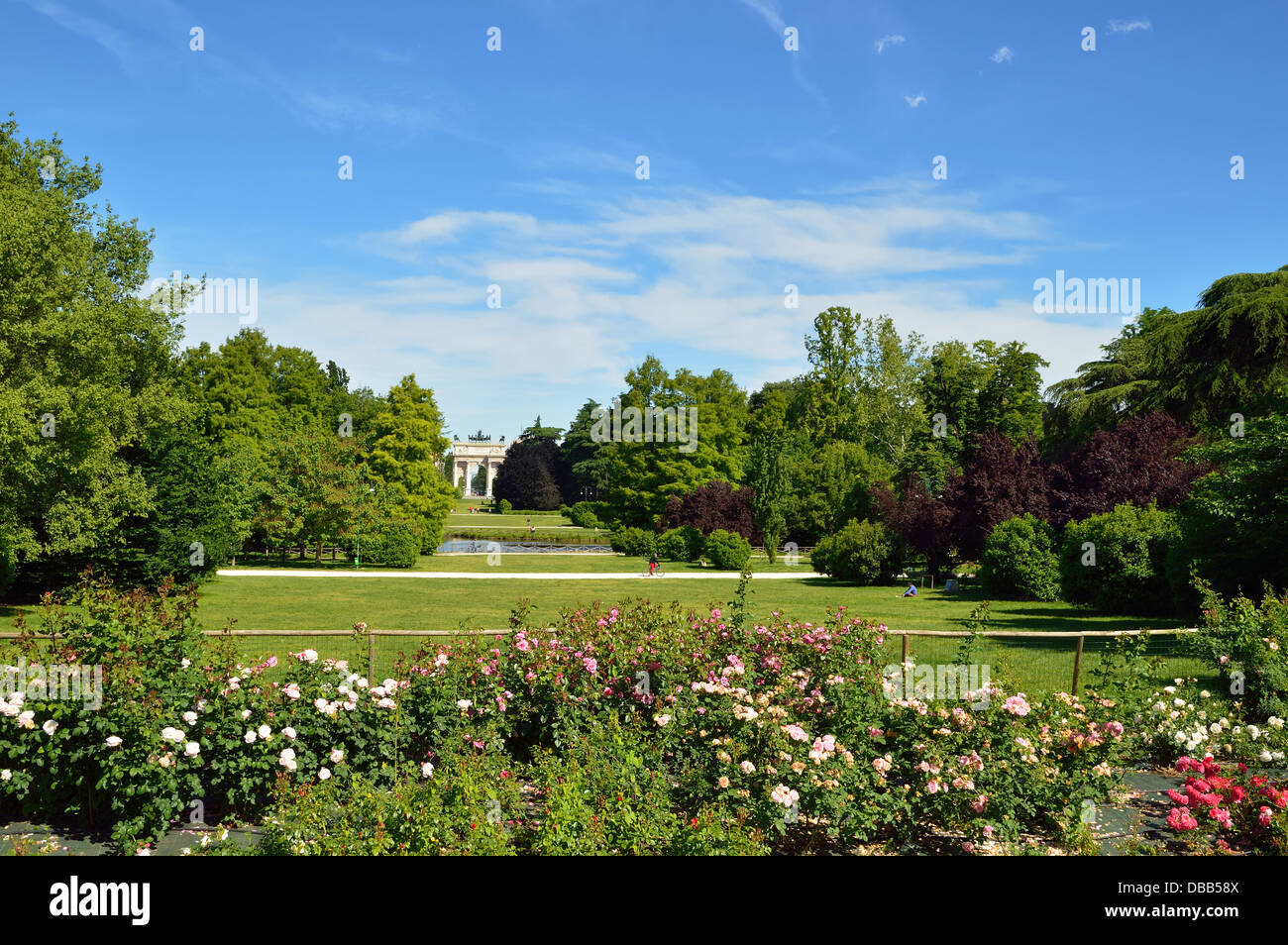 Il parco della città di Milano con rose e arco trionfale dietro Foto Stock