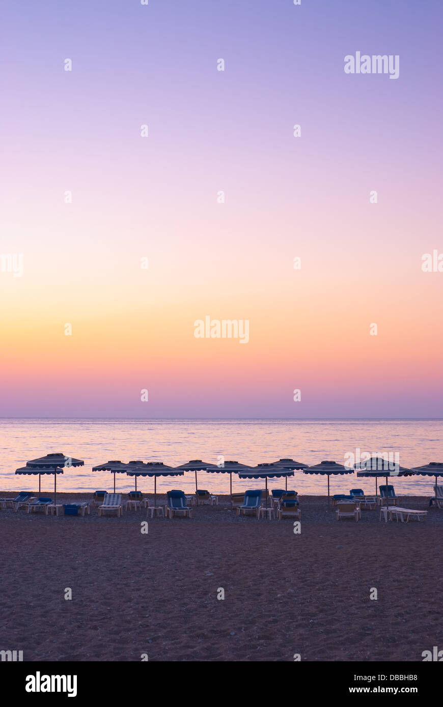 Bellissimo tramonto al mare e ombrelloni sulla spiaggia Foto Stock