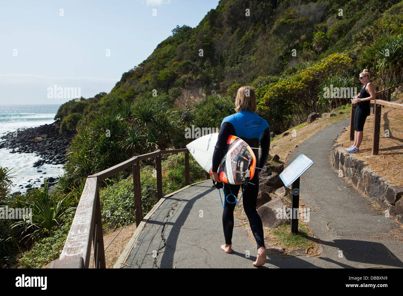 Surfer percorrendo a piedi per la spiaggia. Burleigh capi, Gold Coast, Queensland, Australia Foto Stock