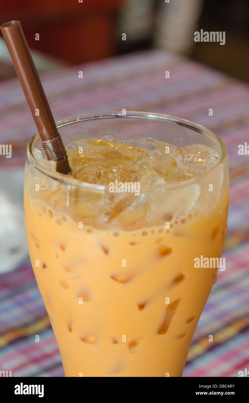 Latte di ghiaccio tè con cannuccia sul tavolo , Foto Stock