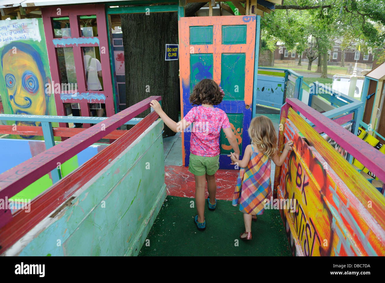I bambini alla scoperta di un albero di casa che è parte del frutto arte di installazione sulla Governors Island per l'estate del 2013. Foto Stock