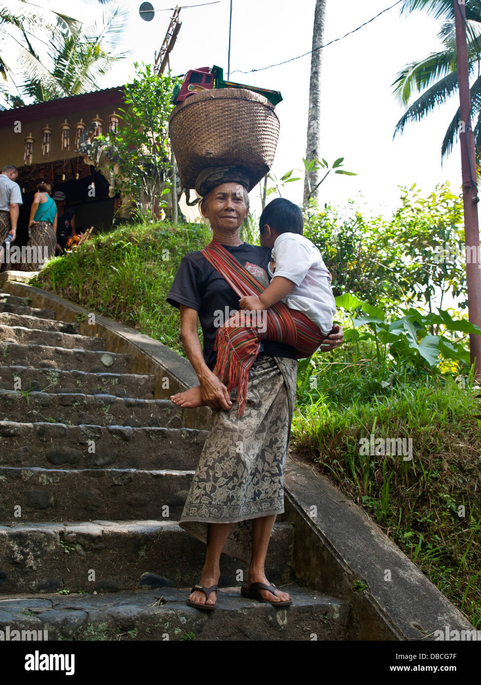 Donna Balinese che trasportano bambino Foto Stock