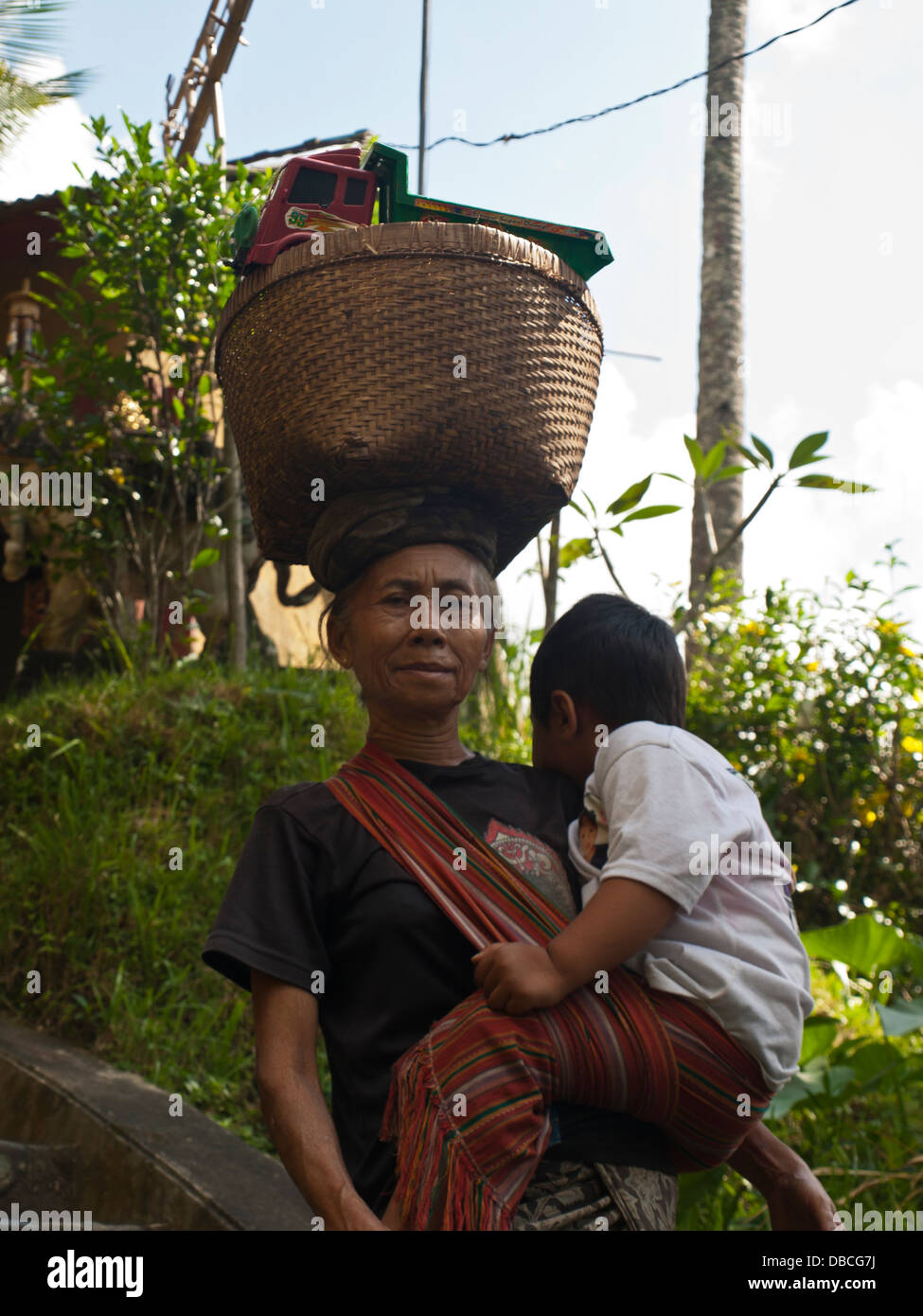 Donna Balinese che trasportano bambino Foto Stock
