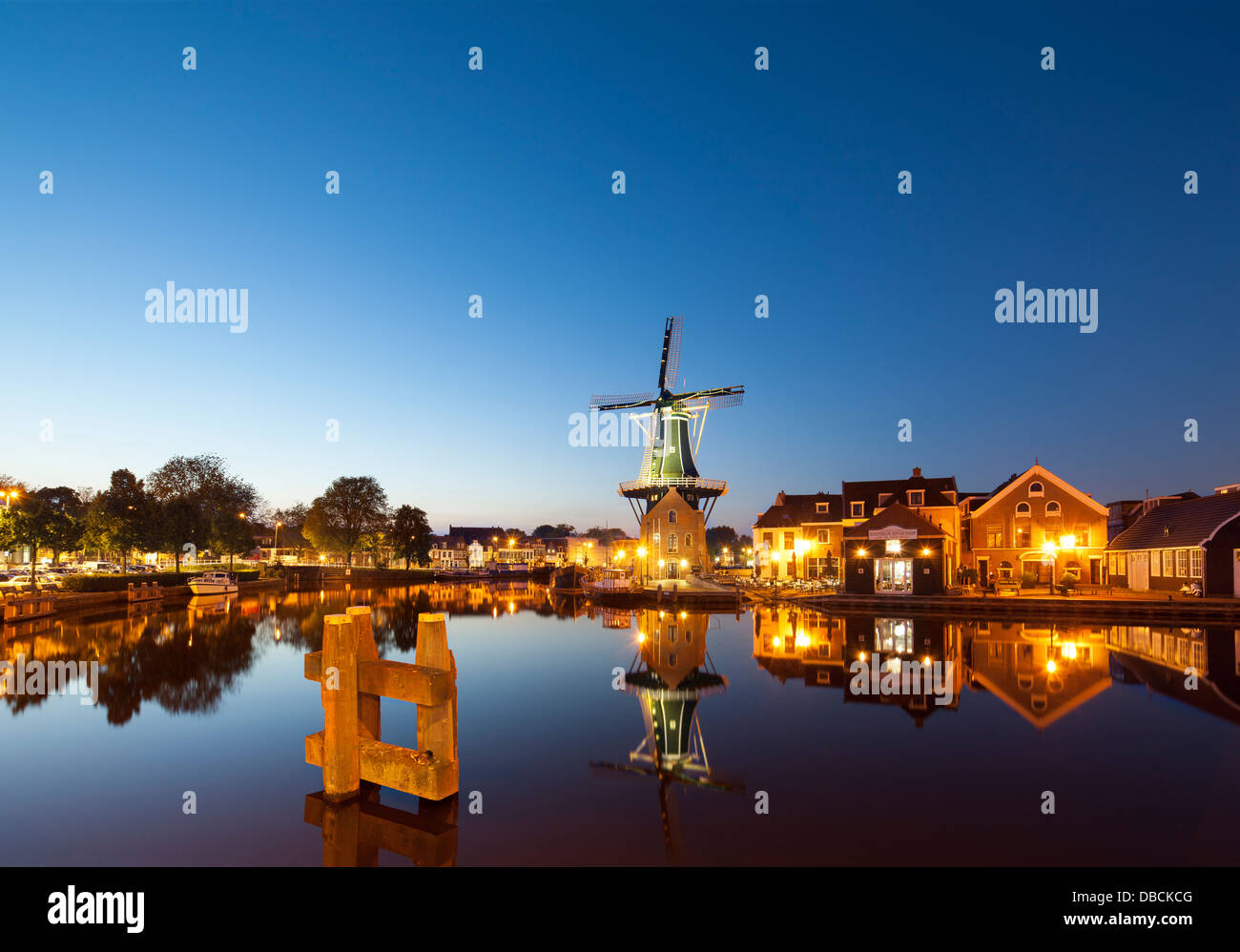 Il mulino a vento di Landmark De Adriaan in Haarlem Holland, Paesi Bassi. Sul fiume Spaarne, canal con ristorante Zuidam al crepuscolo Foto Stock
