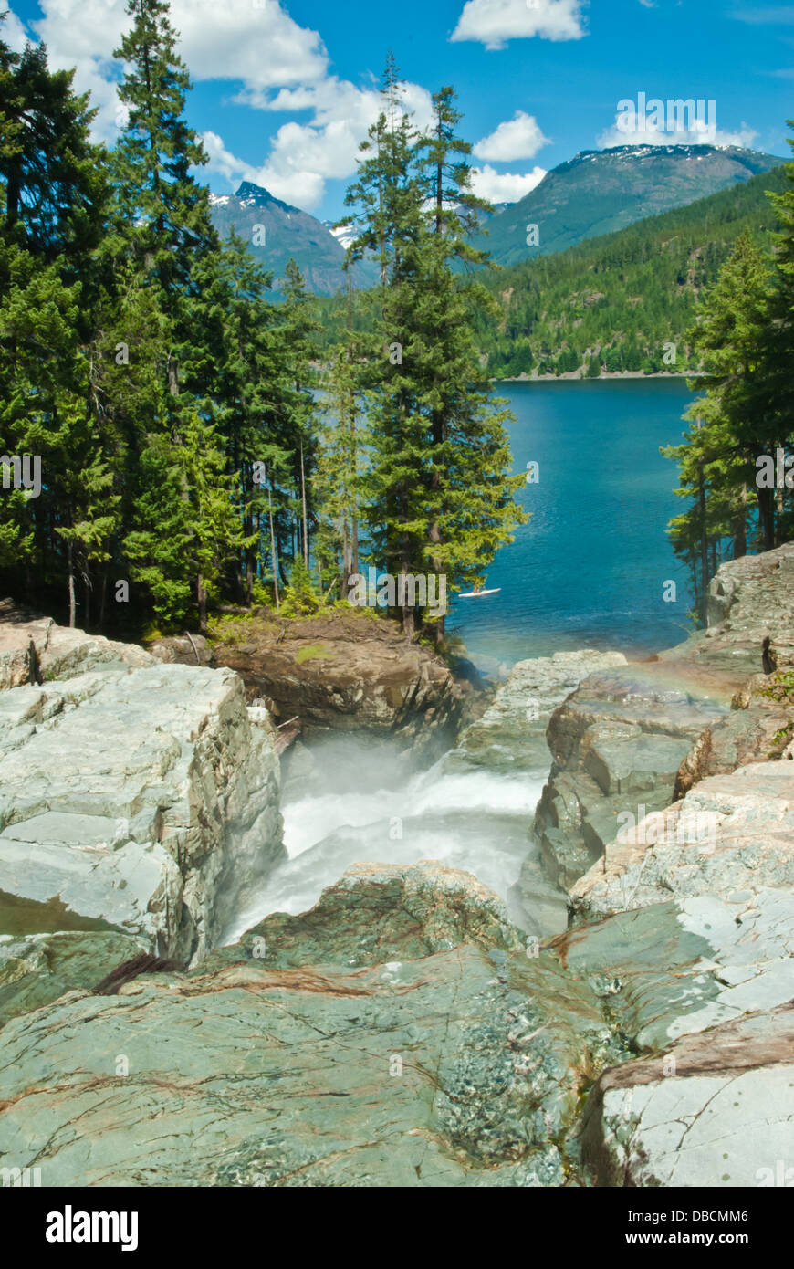 Abbassare Myra cade fluente in Buttle lago con le montagne sullo sfondo, Strathcona Provincial Park, British Columbia Foto Stock