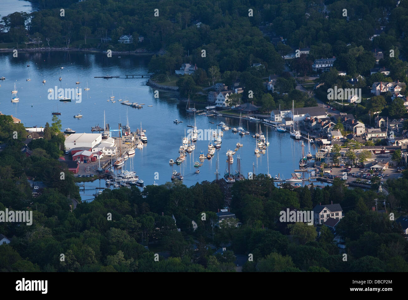 Le barche a vela si trovano nel porto come il sole tramonta sul Camden, Maine Foto Stock