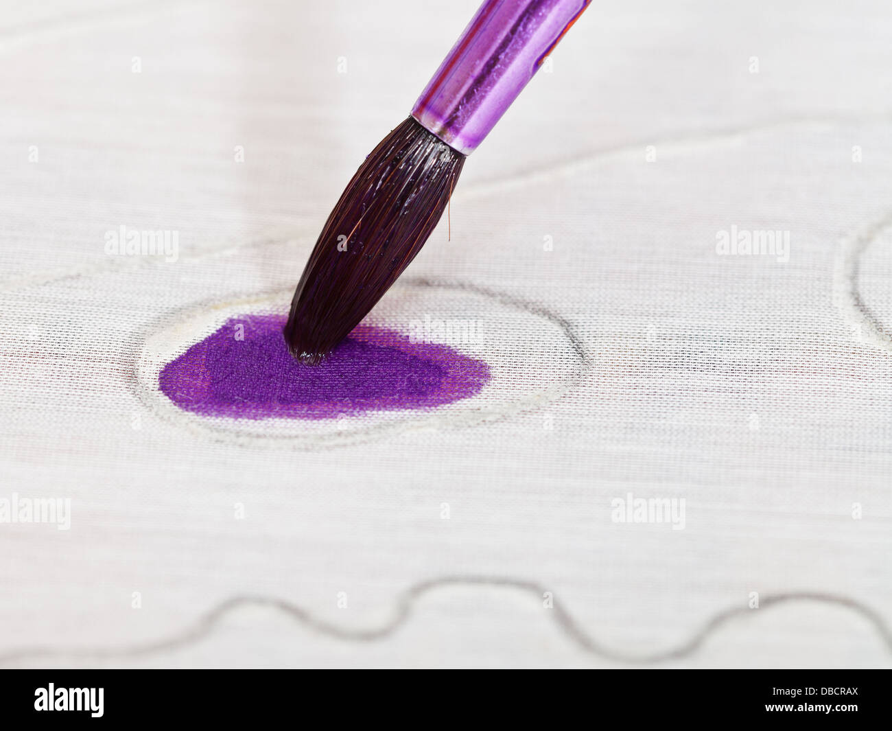 Disegno ornamento viola sulla tela in seta con spazzola vicino fino Foto Stock