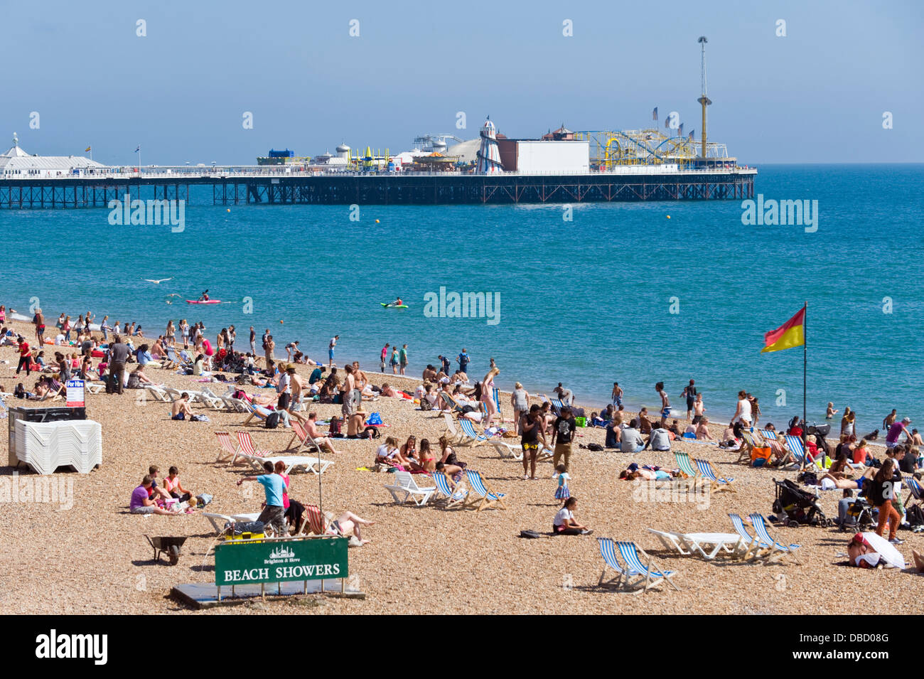I villeggianti rilassarsi in estate il sole sulla spiaggia di Brighton East Sussex England Regno Unito Foto Stock