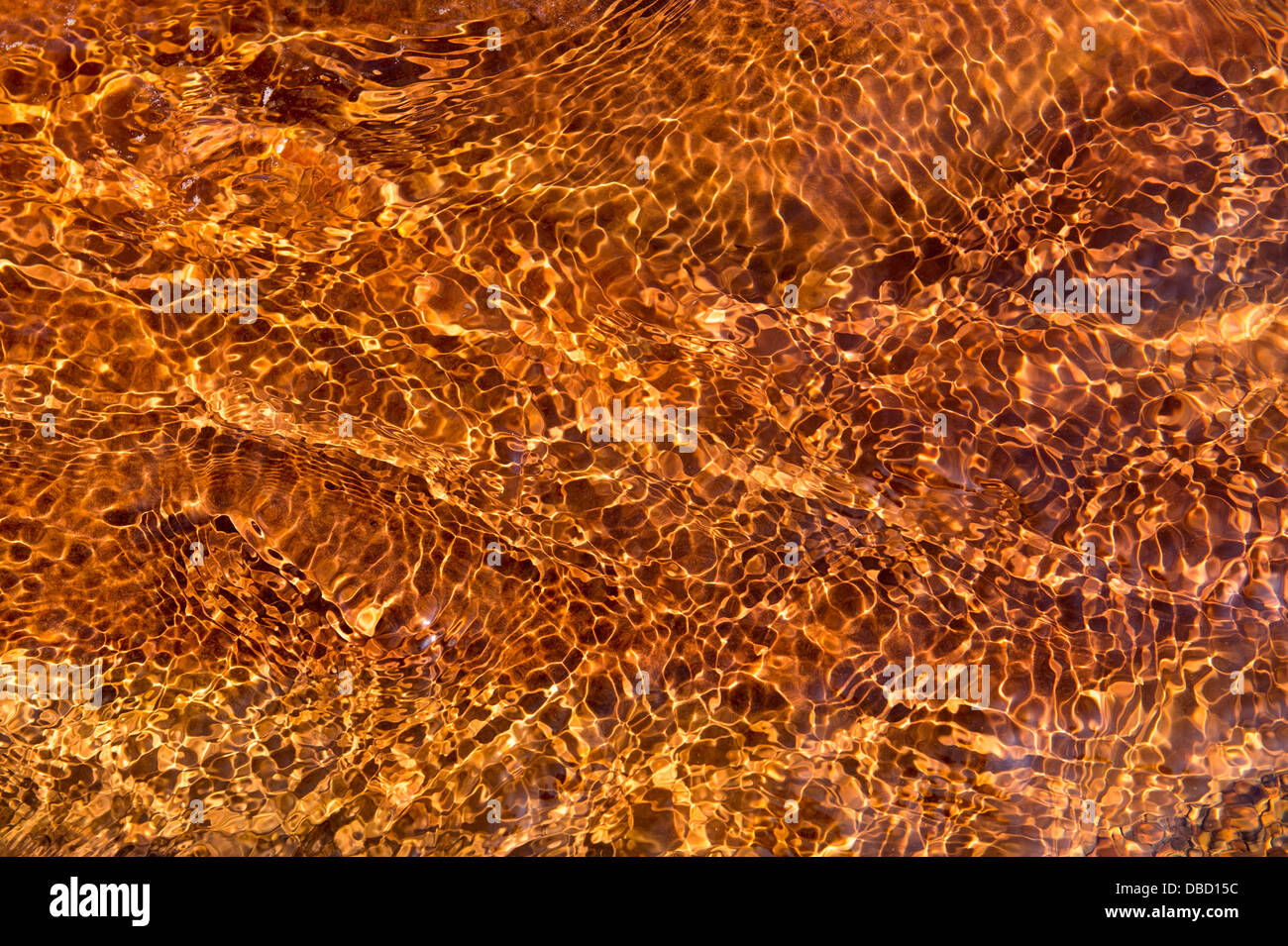 Acqua increspature pattern su ferro colorato di roccia arenaria. Spittal Beach, Northumberland, Inghilterra Foto Stock