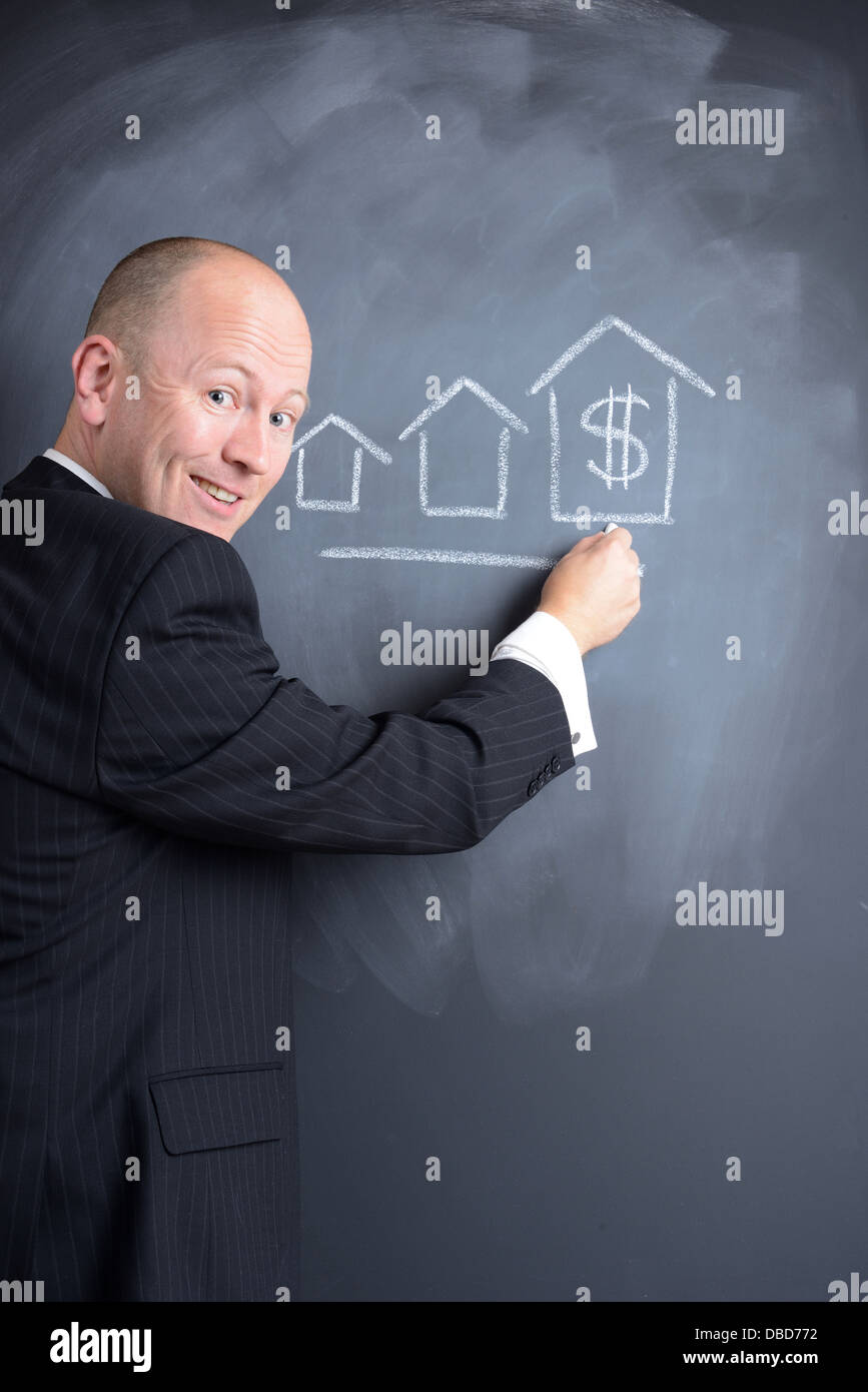 Puntando a un grafico di crescita di costruzione o di alloggiamento su una lavagna Foto Stock