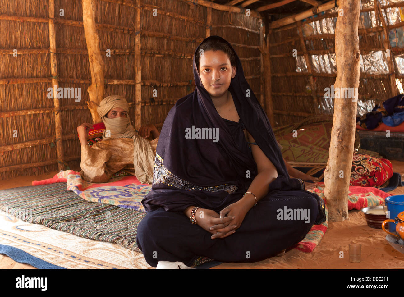 All'interno di Tuareg tenda realizzata da stuoie tessute con il capo villaggio nella casa di sua figlia sposata e suo marito ne Mali Foto Stock