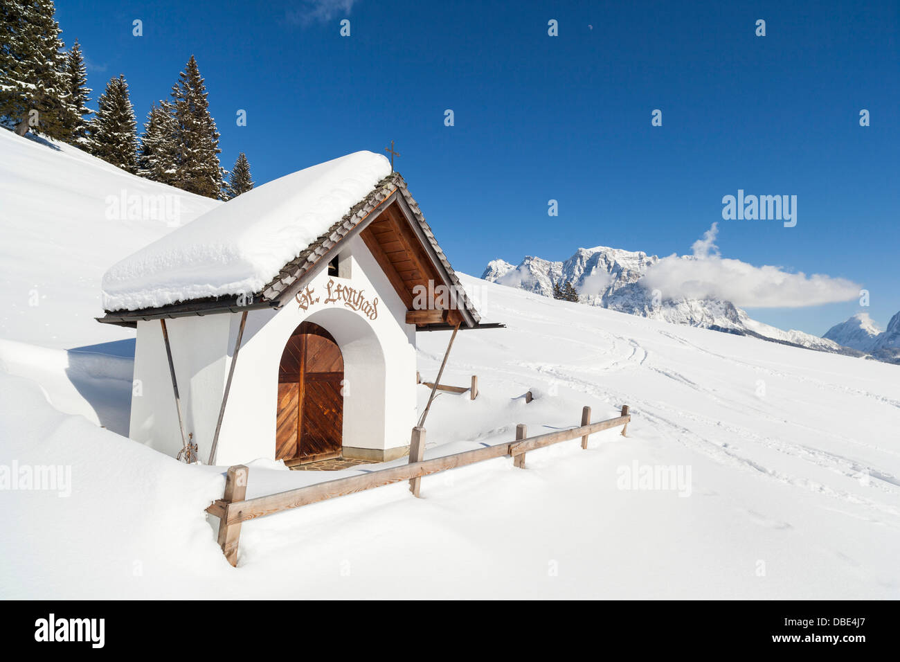 Austria, Tirolo, Ehrwald. La cappella del Tuftel Alm e la montagna Wetterstein catena con Mt. Zugspitze vista da ovest. Foto Stock