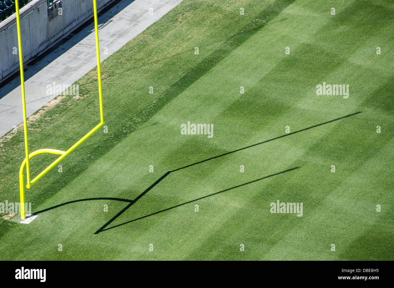 Football Stadium Goal Posts and Field United States // UNITED STATES - uno stadio di calcio professionistico vuoto mette in mostra il suo campo da gioco incontaminato, caratterizzato da erba meticolosamente curata e importanti pali da porta con le loro distintive traverse. I posti a sedere vuoti dello stadio si innalzano sullo sfondo, creando un'atmosfera di attesa per il ruggito della folla e l'eccitazione della giornata di gioco. Foto Stock