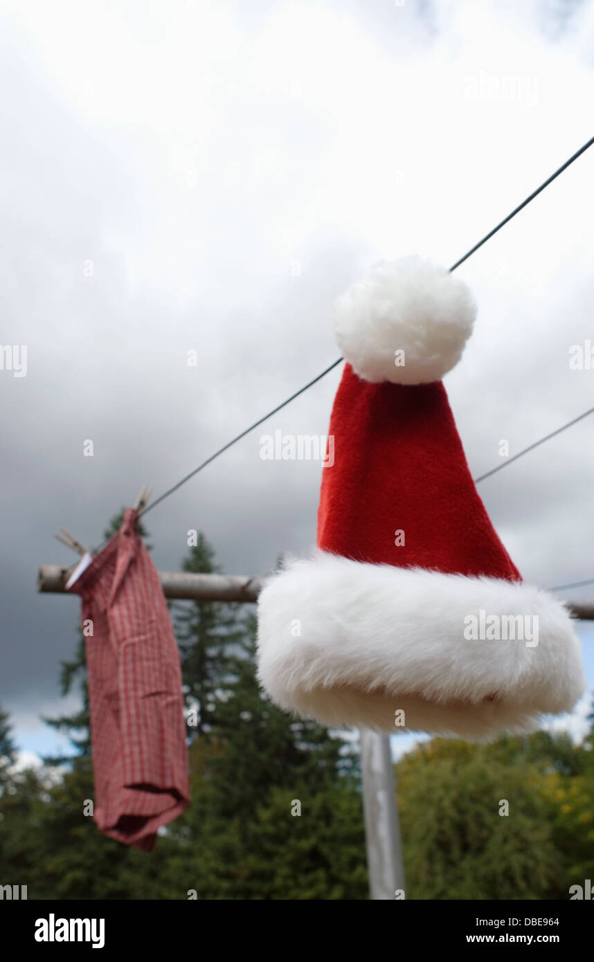 Un cappello da Babbo Natale e un paio di boxer appeso su uno stendibiancheria Foto Stock