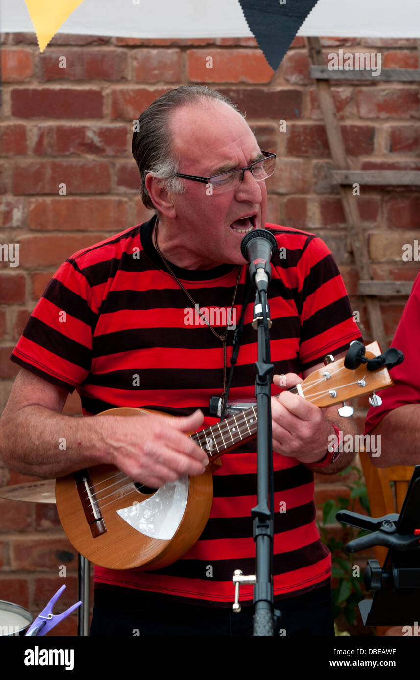 Uomo di cantare e suonare un ukulele. Foto Stock