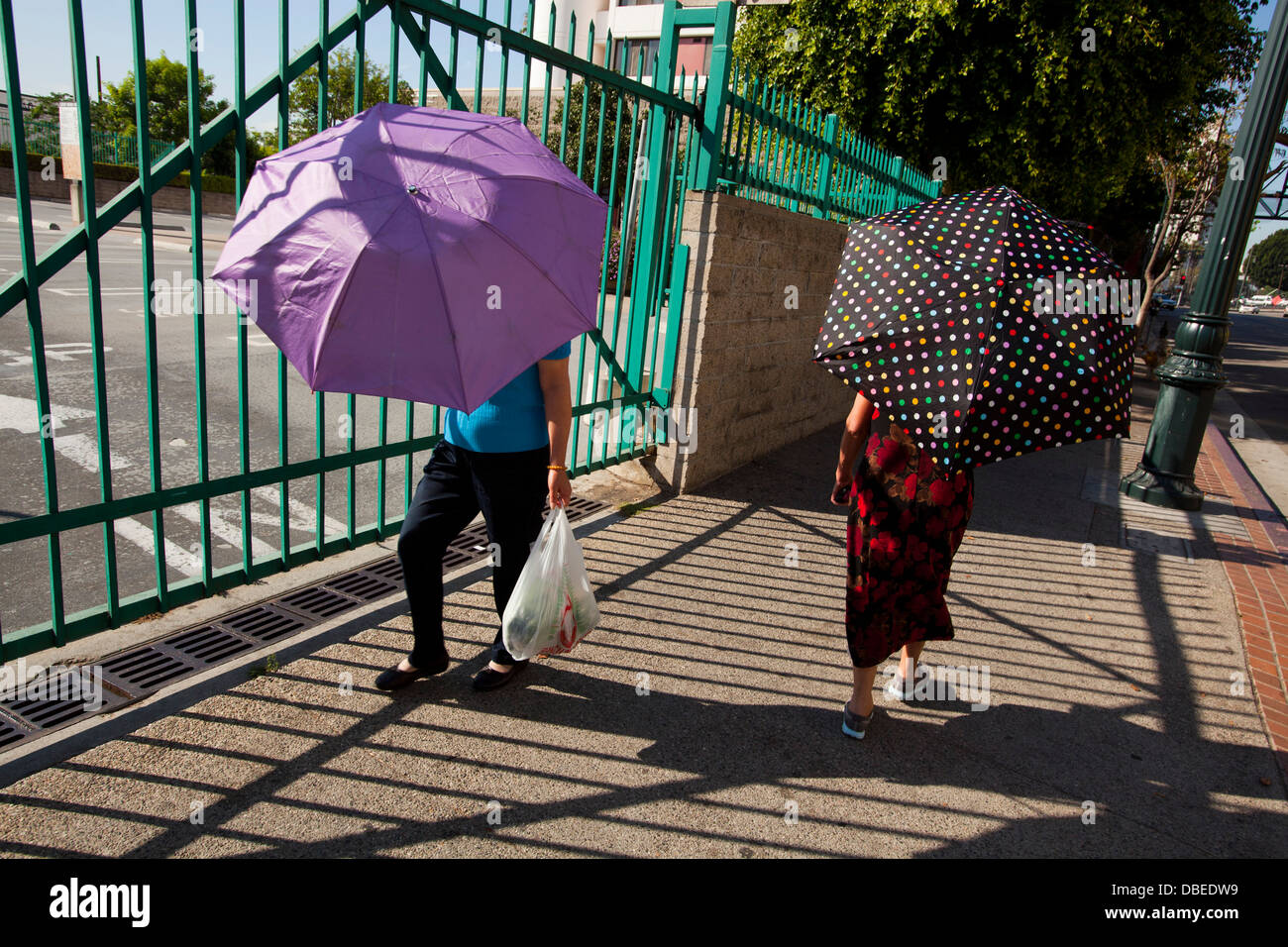 Battere i record di calore in Chinatown. Le donne usano ombrelloni. Los Angeles, California Foto Stock