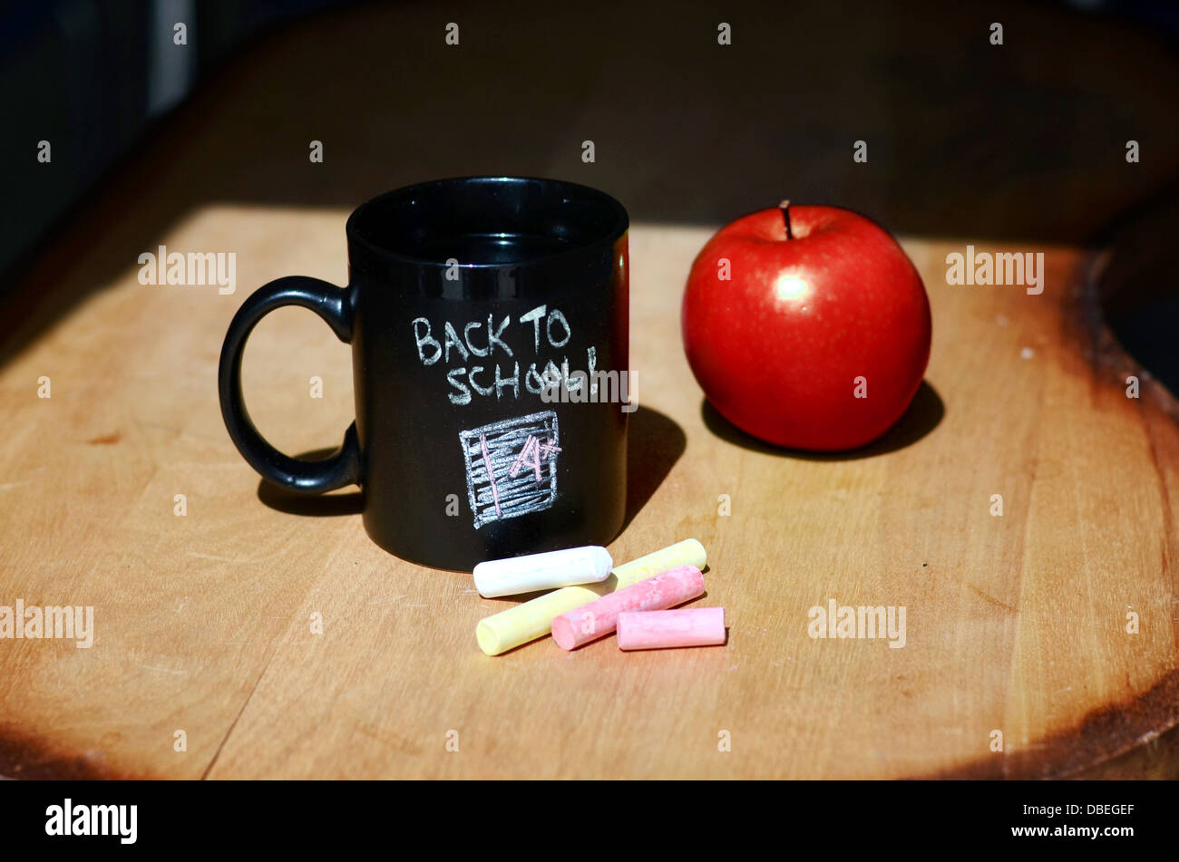 Si torna a scuola lavagna bollitore per tè e caffè mug e gesso su una  scrivania con un rosso apple Foto stock - Alamy