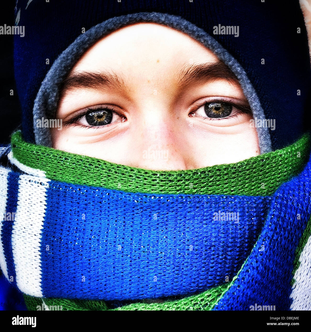Ragazzo caucasico con la faccia avvolta in una sciarpa Foto Stock