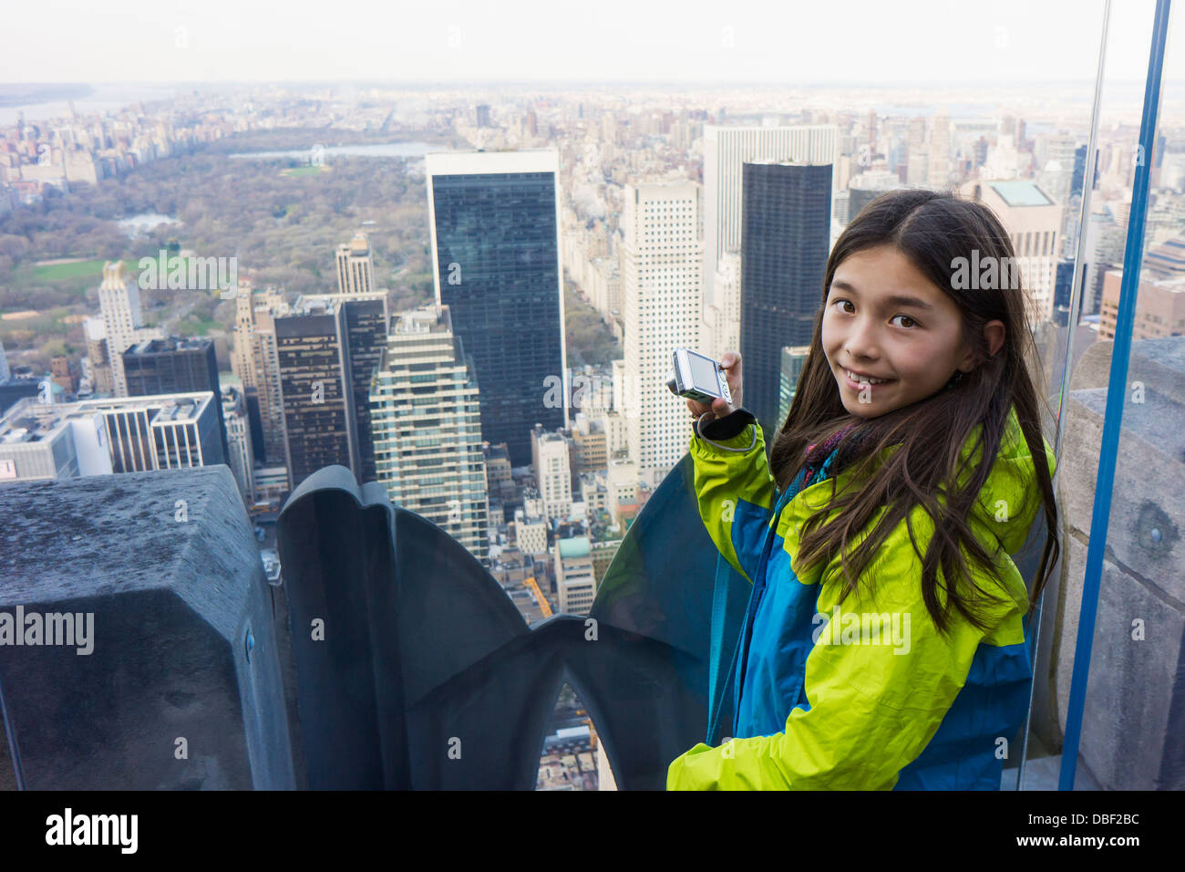 Razza mista ragazza di scattare le foto dal tetto, la città di New York, New York, Stati Uniti Foto Stock