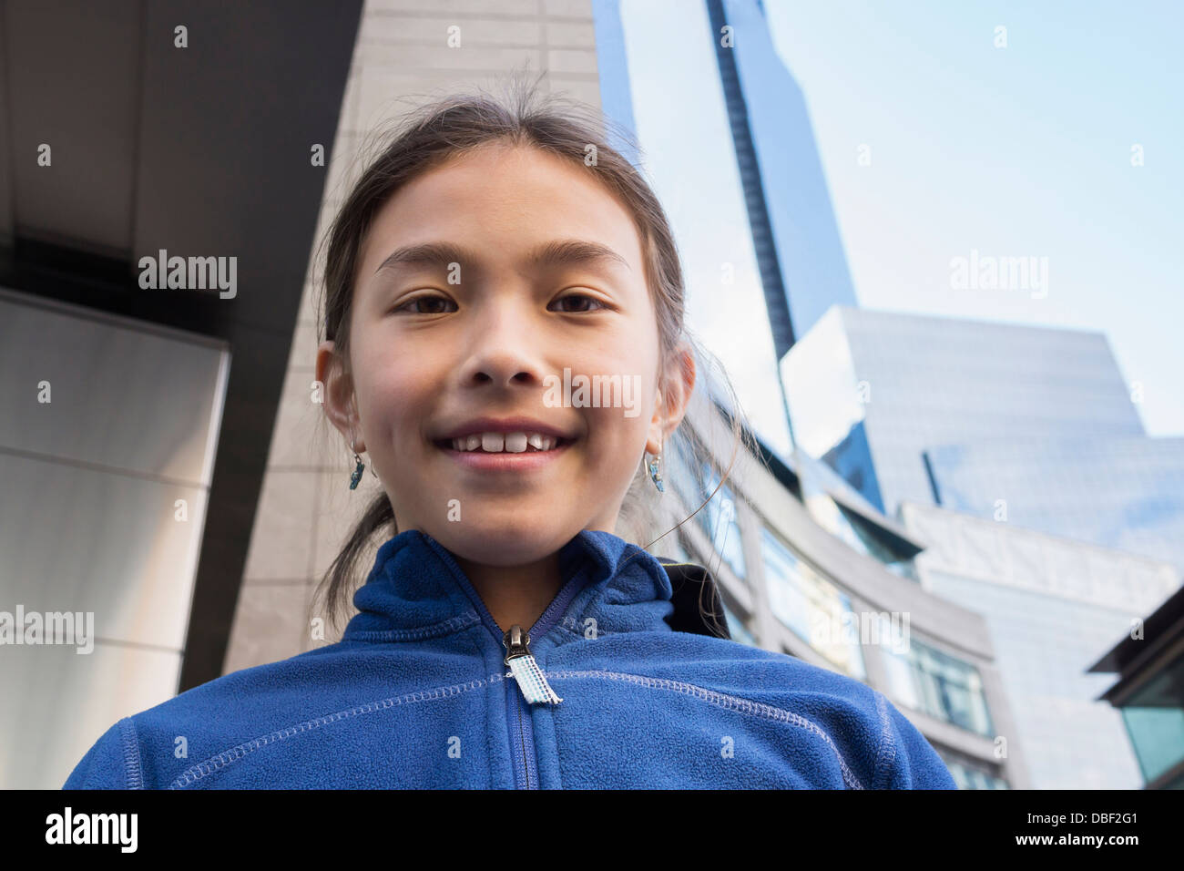 Razza mista ragazza sorridente su una strada di città Foto Stock