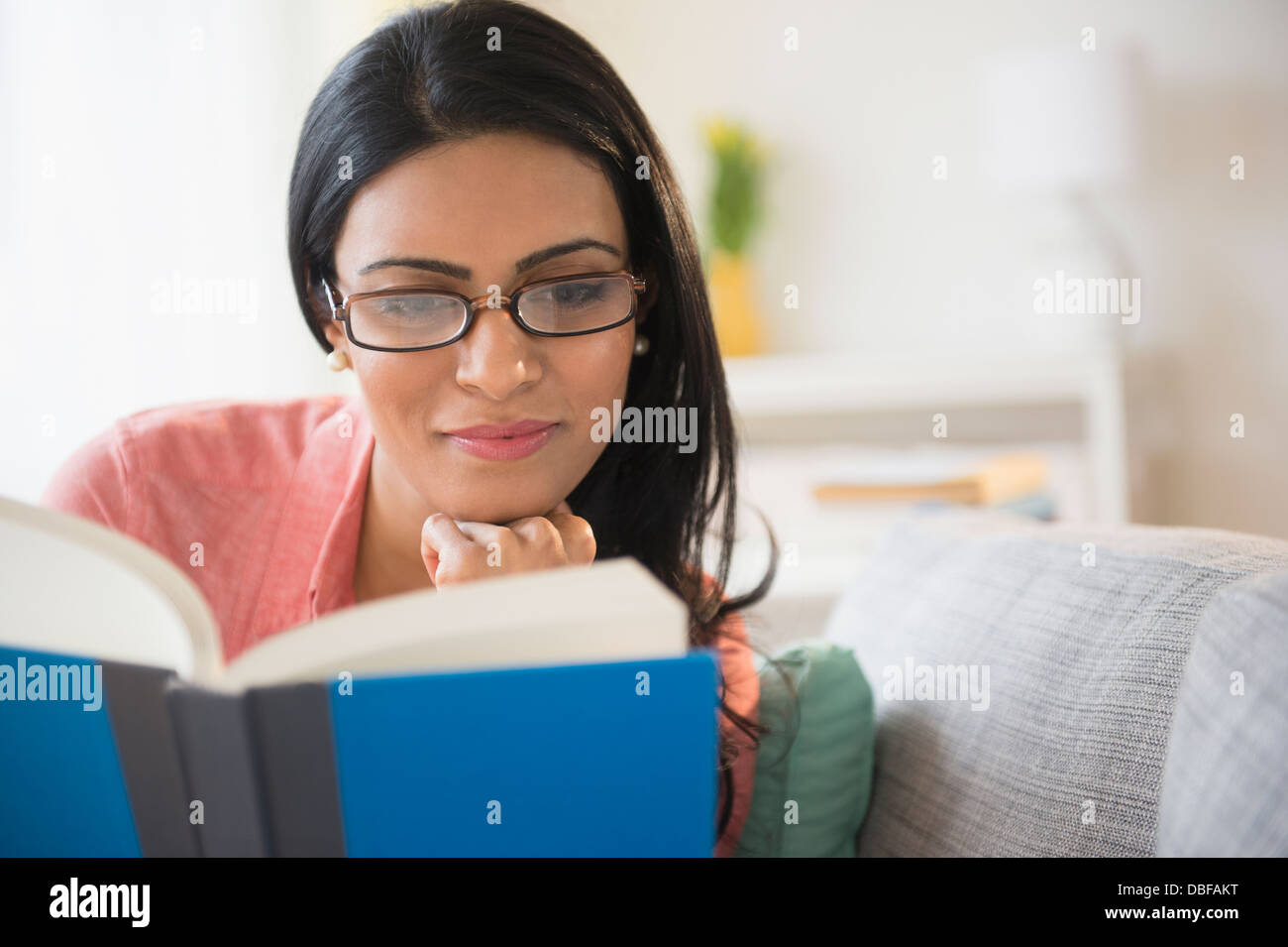Donna indiana la lettura sul divano Foto Stock