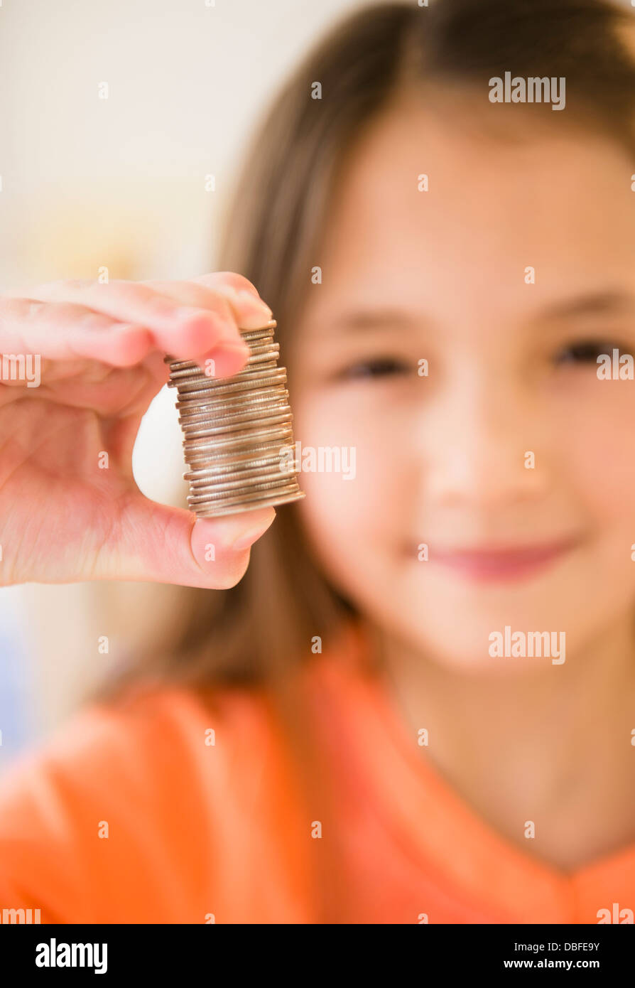 Razza mista ragazza con pila di monete Foto Stock