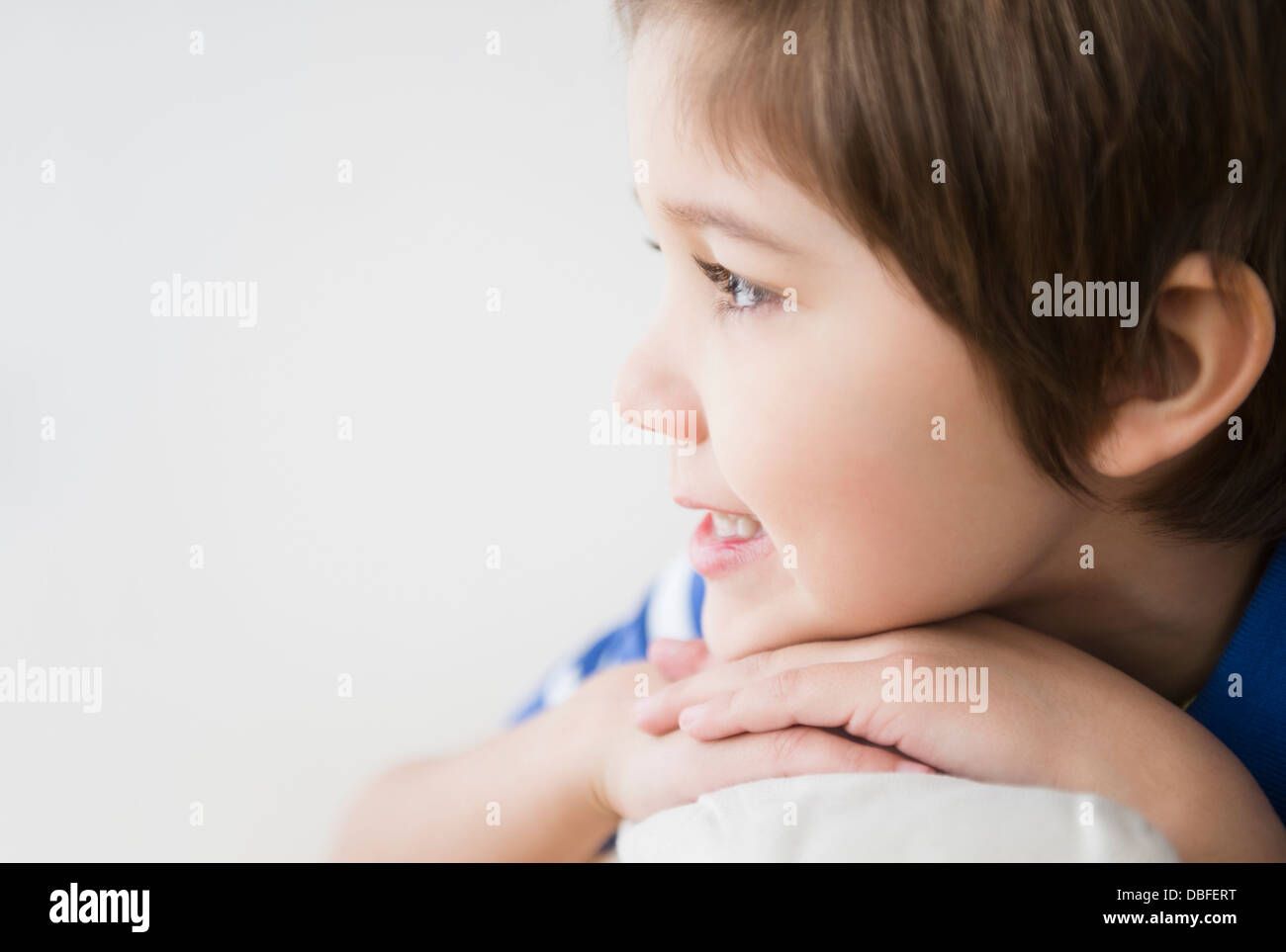 Ispanico boy mento di appoggio sulle mani Foto Stock