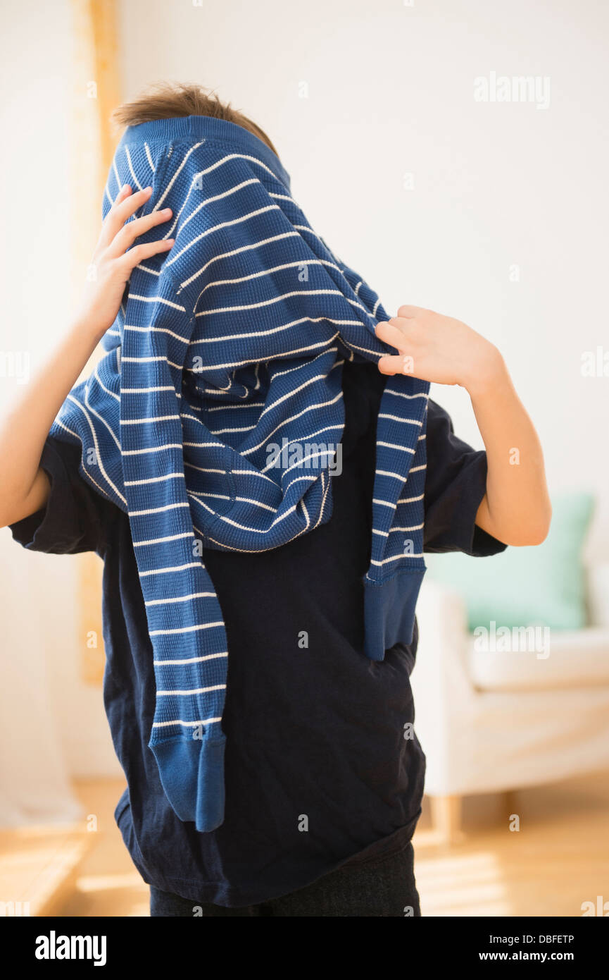 Ragazzo ispanico tirando il maglione Foto Stock