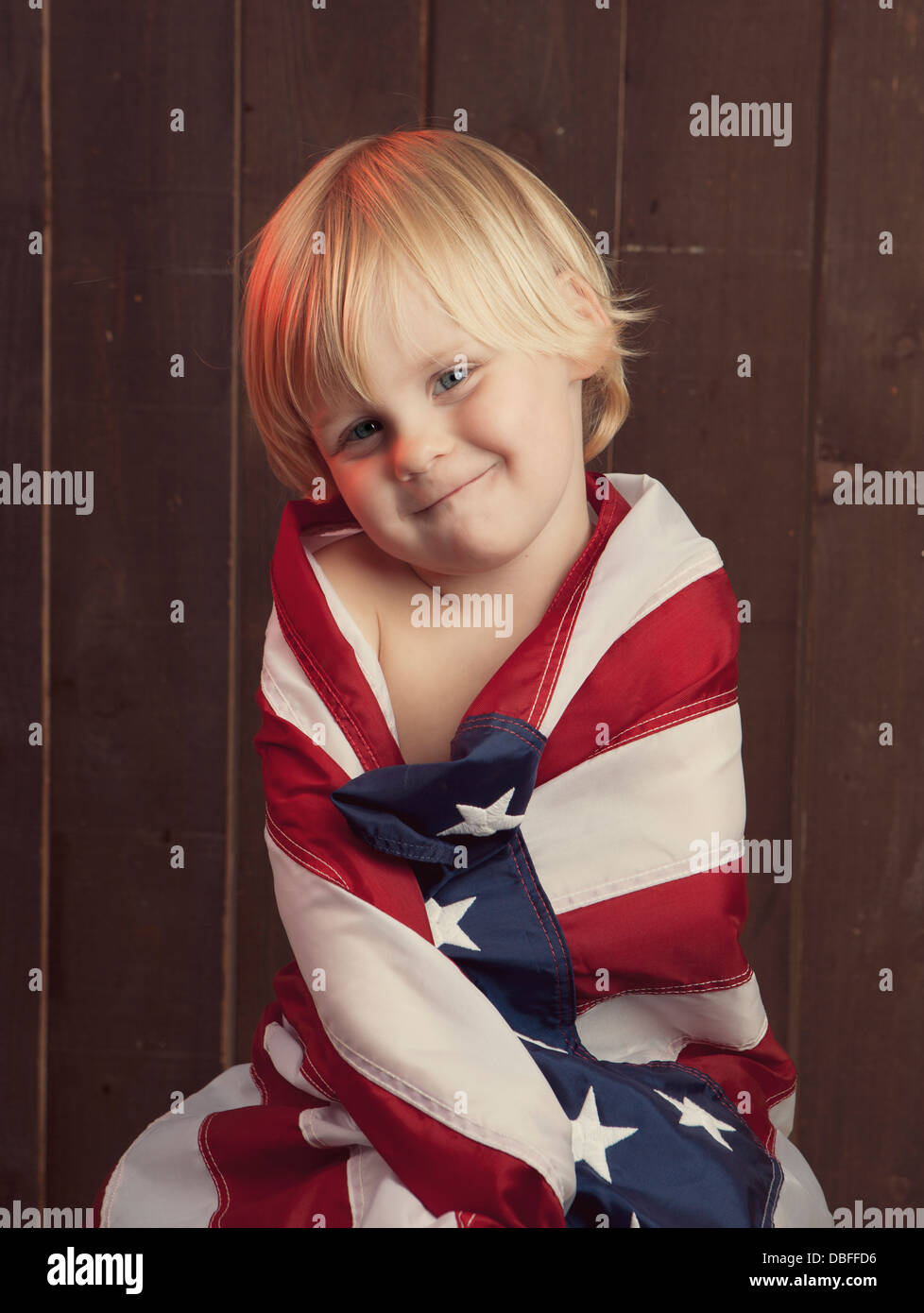 Ragazzo caucasico avvolto nella Bandiera americana Foto Stock