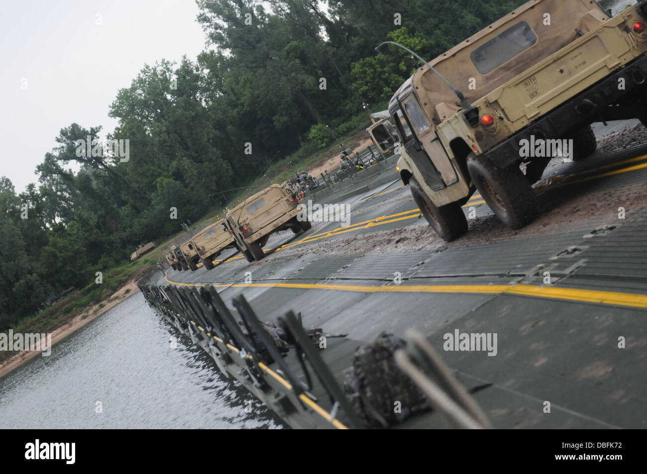 Un elemento di sicurezza convoglio viaggia attraverso un miglioramento finito ponte di nastro durante il funzionamento fiume assalto Luglio 24, 2013. Il ponte è stato l'esercizio finale per quasi 800 soldati in rappresentanza di entrambi gli Stati Uniti La riserva di esercito e active duty componenti. Foto Stock