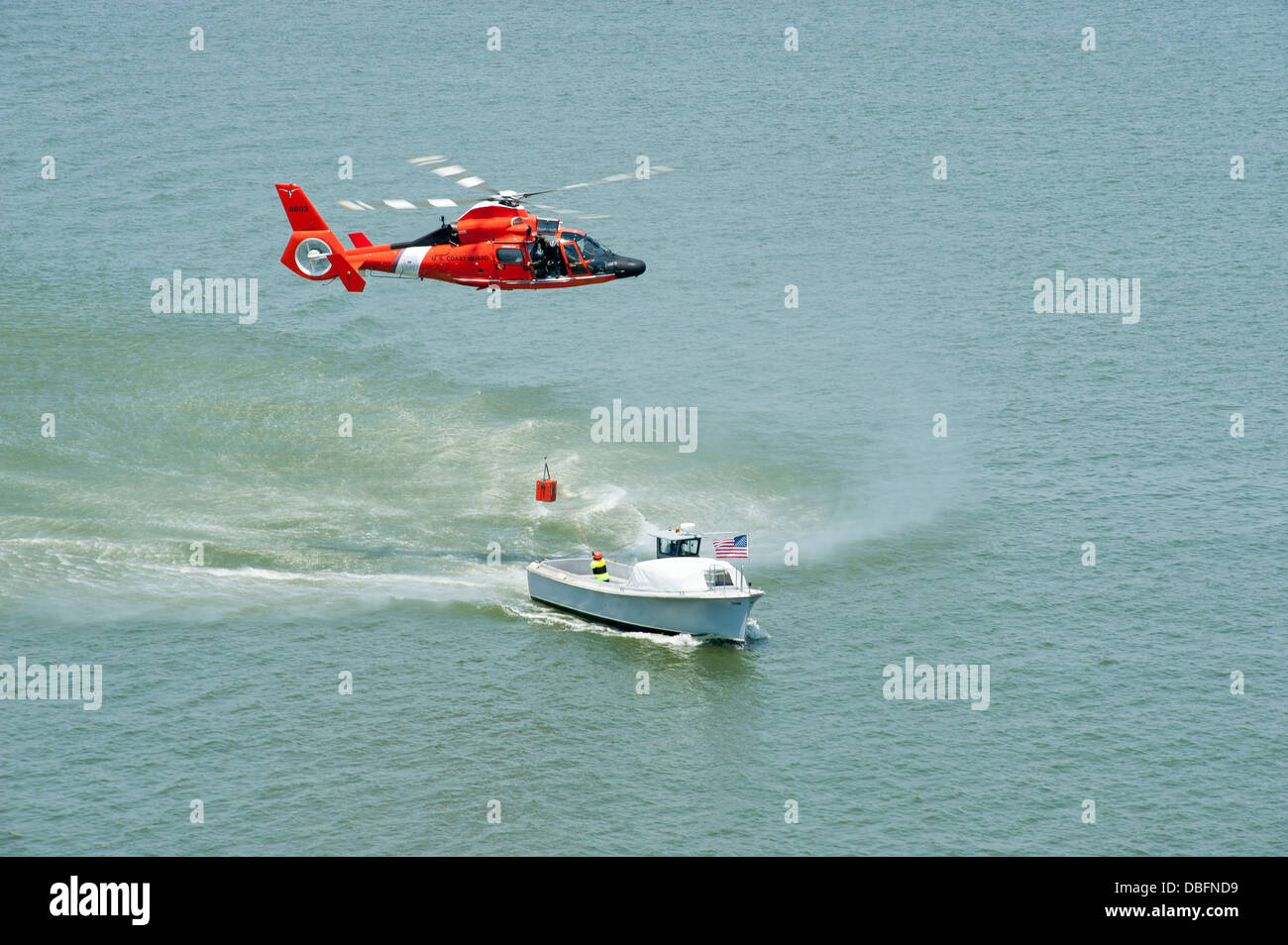 La guardia costiera della stazione aria Houston equipaggi consegna pratiche e tecniche di sollevamento per una idrovora durante un volo di formazione su Houston canale nave a bordo di un MH-65D Delfino elicottero Luglio 25, 2013. Foto Stock