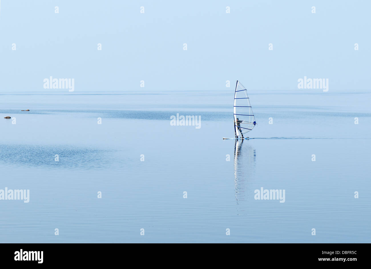 Windsurf panorama silhouette contro la scintillante mare blu Foto Stock