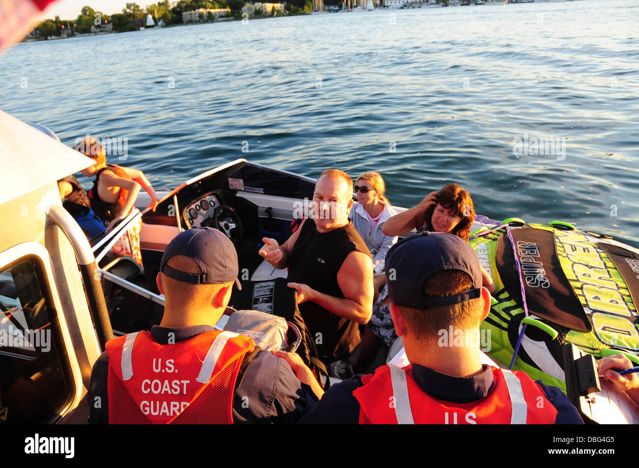 Fireman Jared Lawhead, un imbarco teammember dalla Stazione della Guardia Costiera Niagara, ispeziona un giubbotto di salvataggio durante una sicurezza di salire a bordo di un battello da diporto sul fiume Niagara in prossimità di Youngstown, N.Y., luglio 26, 2013. La guardia costiera conduce la sicurezza Foto Stock