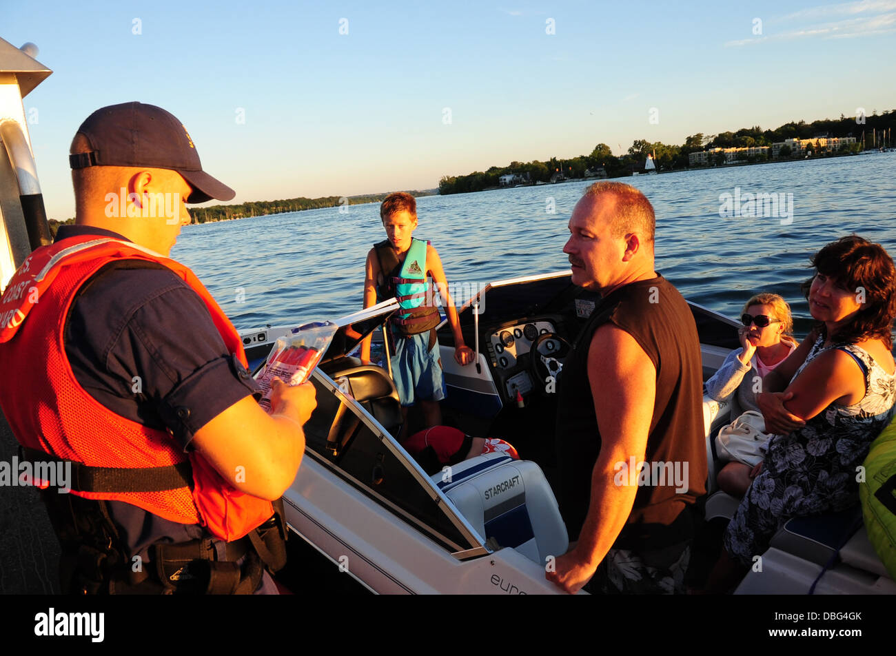 Fireman Jared Lawhead, un imbarco teammember dalla Stazione della Guardia Costiera Niagara, esamina un pacchetto di razzi durante una sicurezza di salire a bordo di un battello da diporto sul fiume Niagara in prossimità di Youngstown, N.Y., luglio 26, 2013. La guardia costiera conduce s Foto Stock