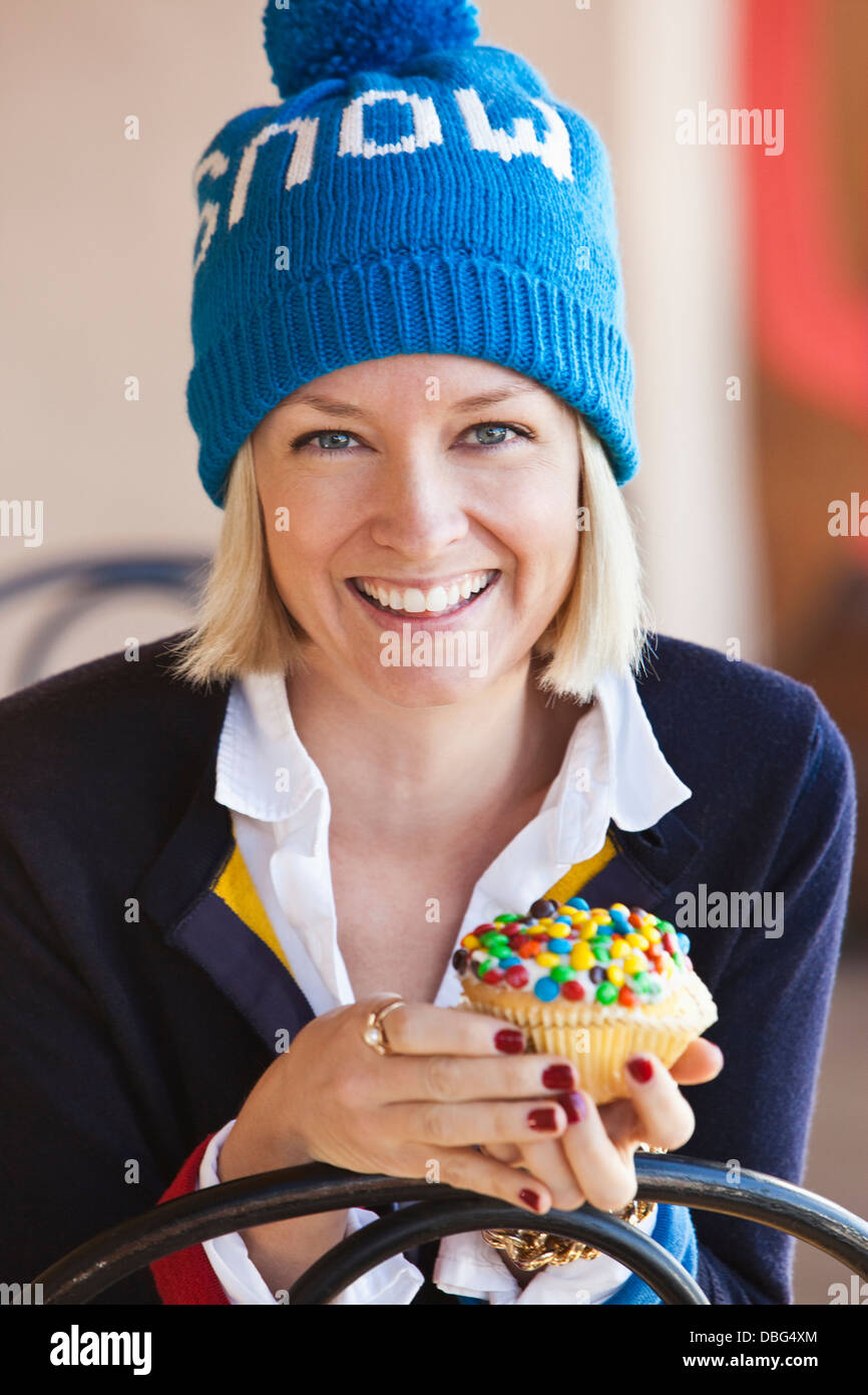 La donna caucasica mangiare cupcake Foto Stock