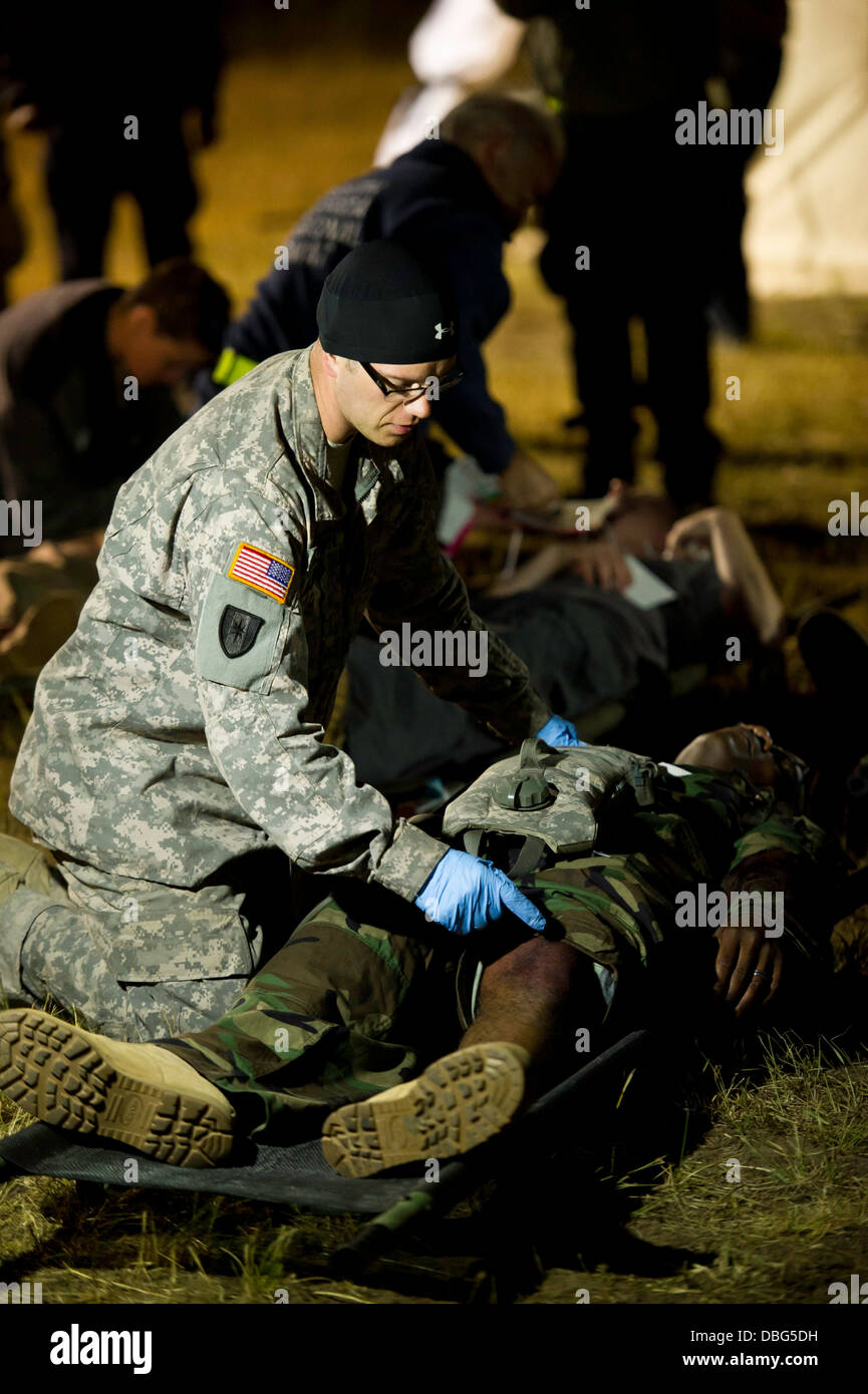 Un U.S. Esercito Corp. Joshua Donovan, con il 1982 in avanti il team chirurgico, Niagara Falls, N.Y., triages la simulazione di una vittima in un incidente di massa scenario, a sostegno di un guerriero esercizio 86-13-01 (WAREX)/esercizio Global Medic 2013, Fort McCoy, Wis., luglio 27, 2013 Foto Stock