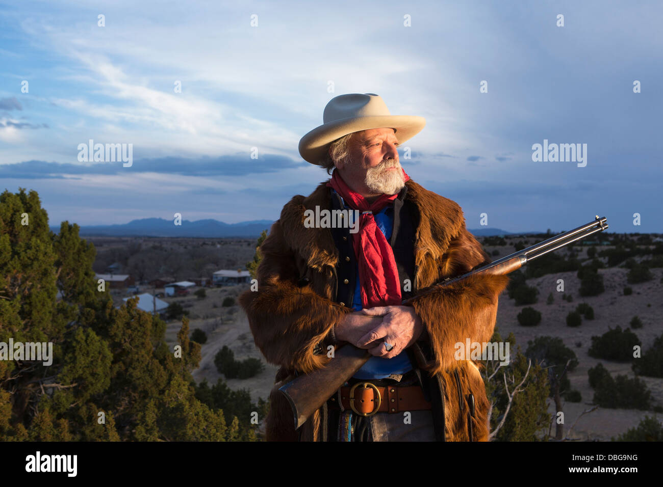 Uomo caucasico tenendo la pistola nel paesaggio polveroso Foto Stock