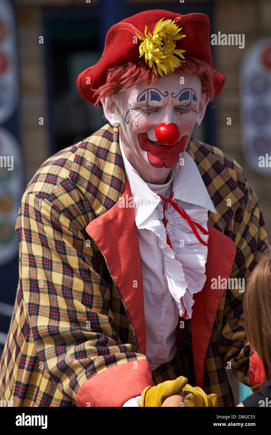 Clown intrattenere la folla per Swanage Carnival Procession, Swanage, Dorset UK nel mese di luglio Foto Stock