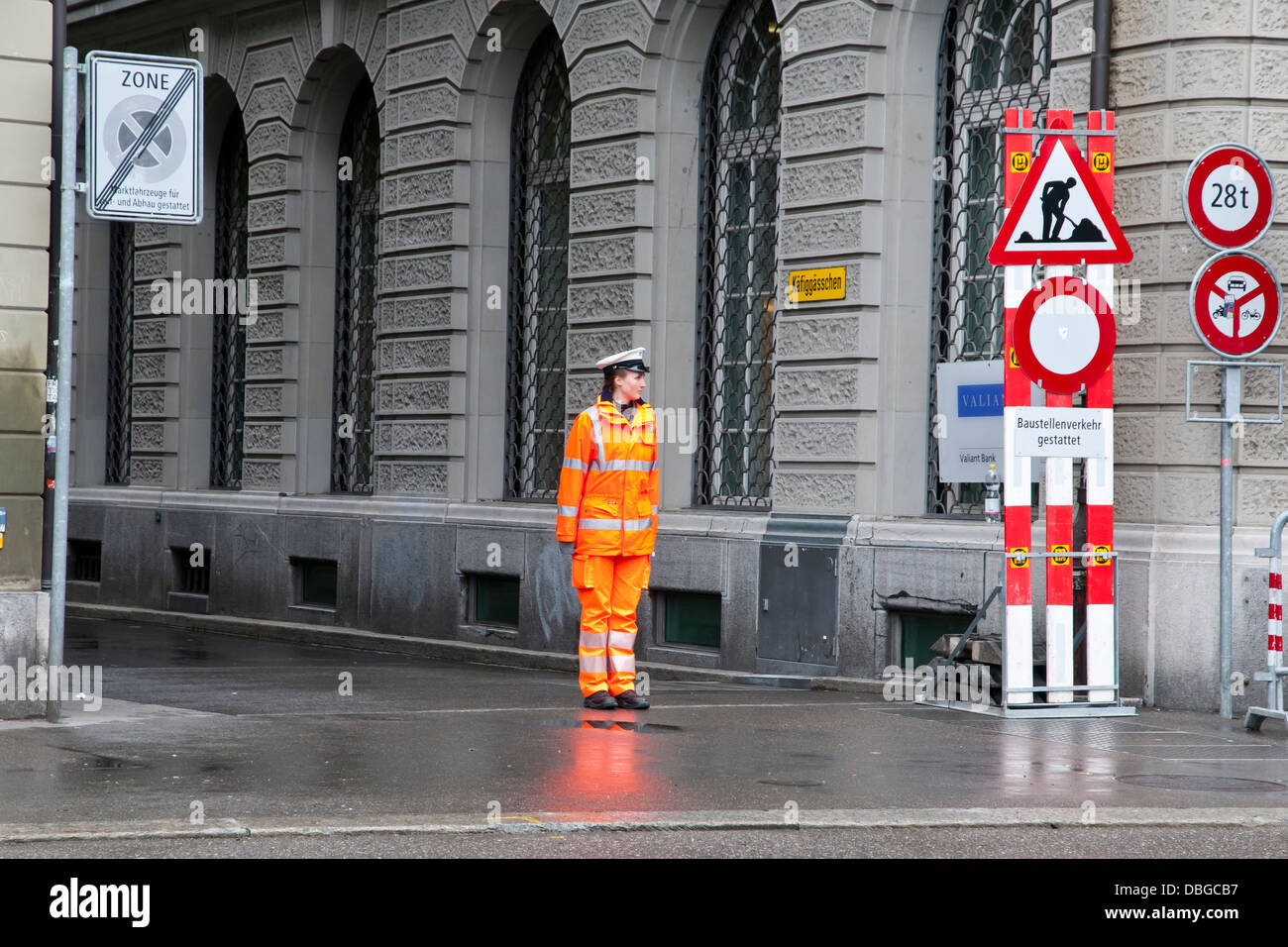 Il dispositivo di controllo di traffico, una donna della polizia in uniforme arancione giornata piovosa, Berna , Svizzera, Europa Foto Stock