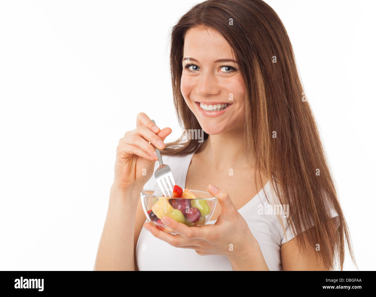 Pretty Woman mangiare frutta con una forchetta, isolato su bianco Foto Stock