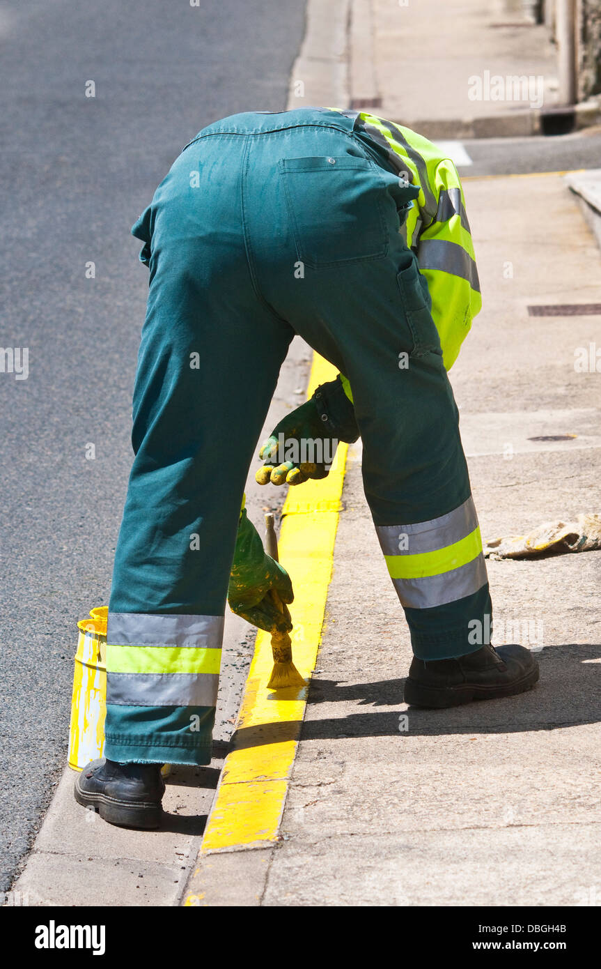 Consiglio lavoratore dipinto 'n' attesa linea gialla sul cordolo stradale - Francia. Foto Stock