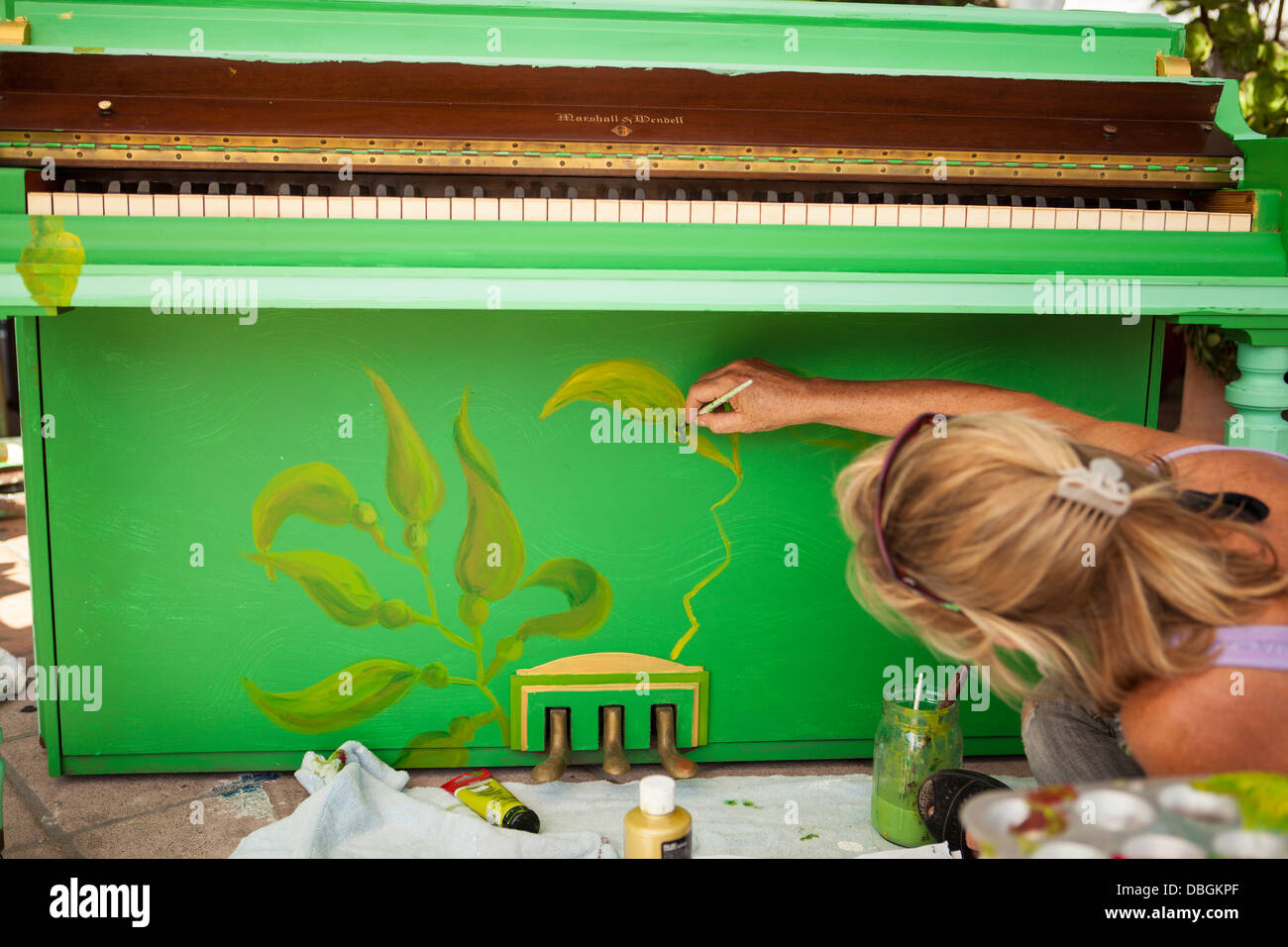 Artista Lisa James dipinge un pianoforte per i pianoforti sul progetto di stato al Red's Bar, la zona di Funk, Santa Barbara, California Foto Stock