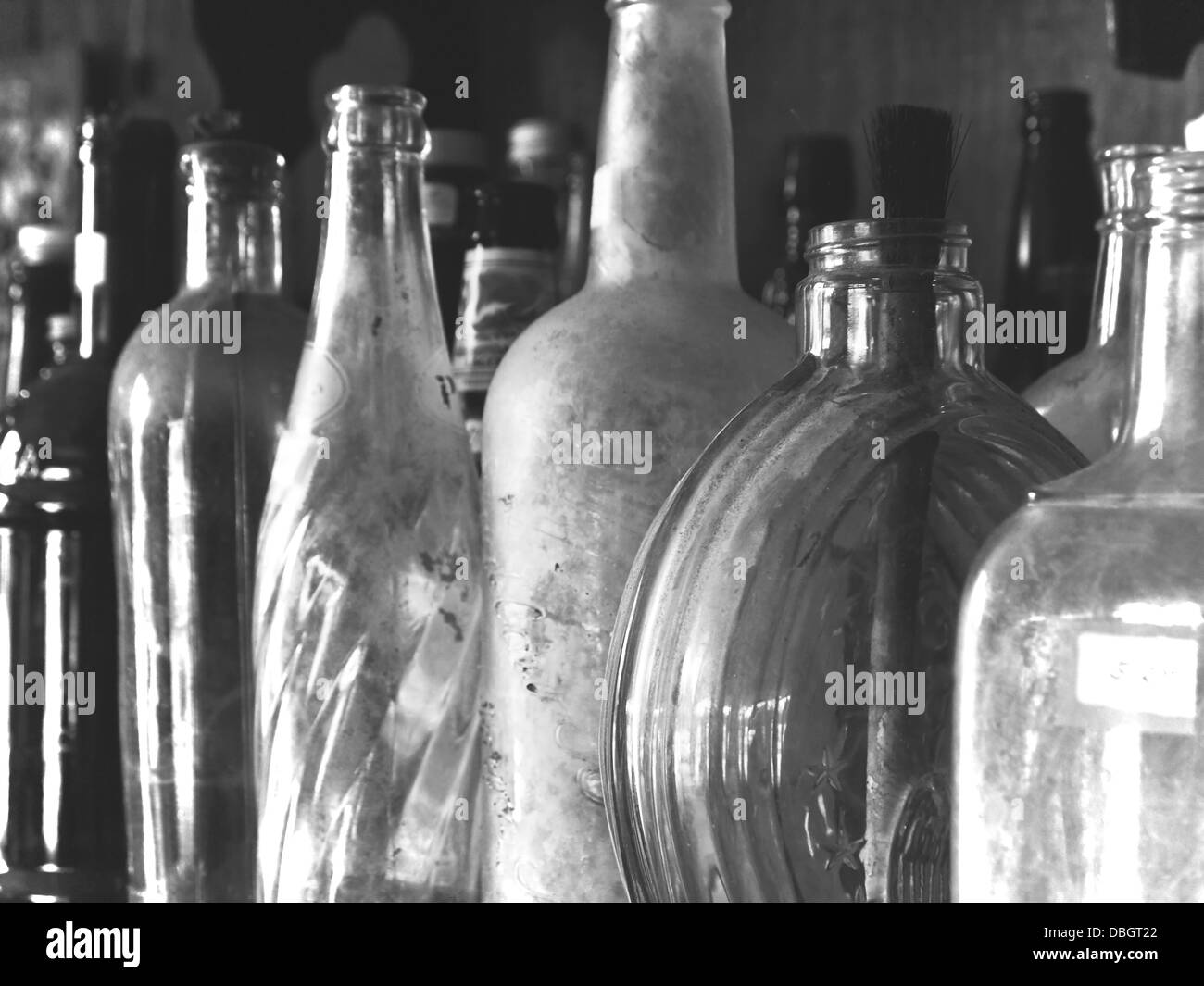 Sfondo con una collezione di antichi le bottiglie di vetro, closeup, in bianco e nero. Foto Stock