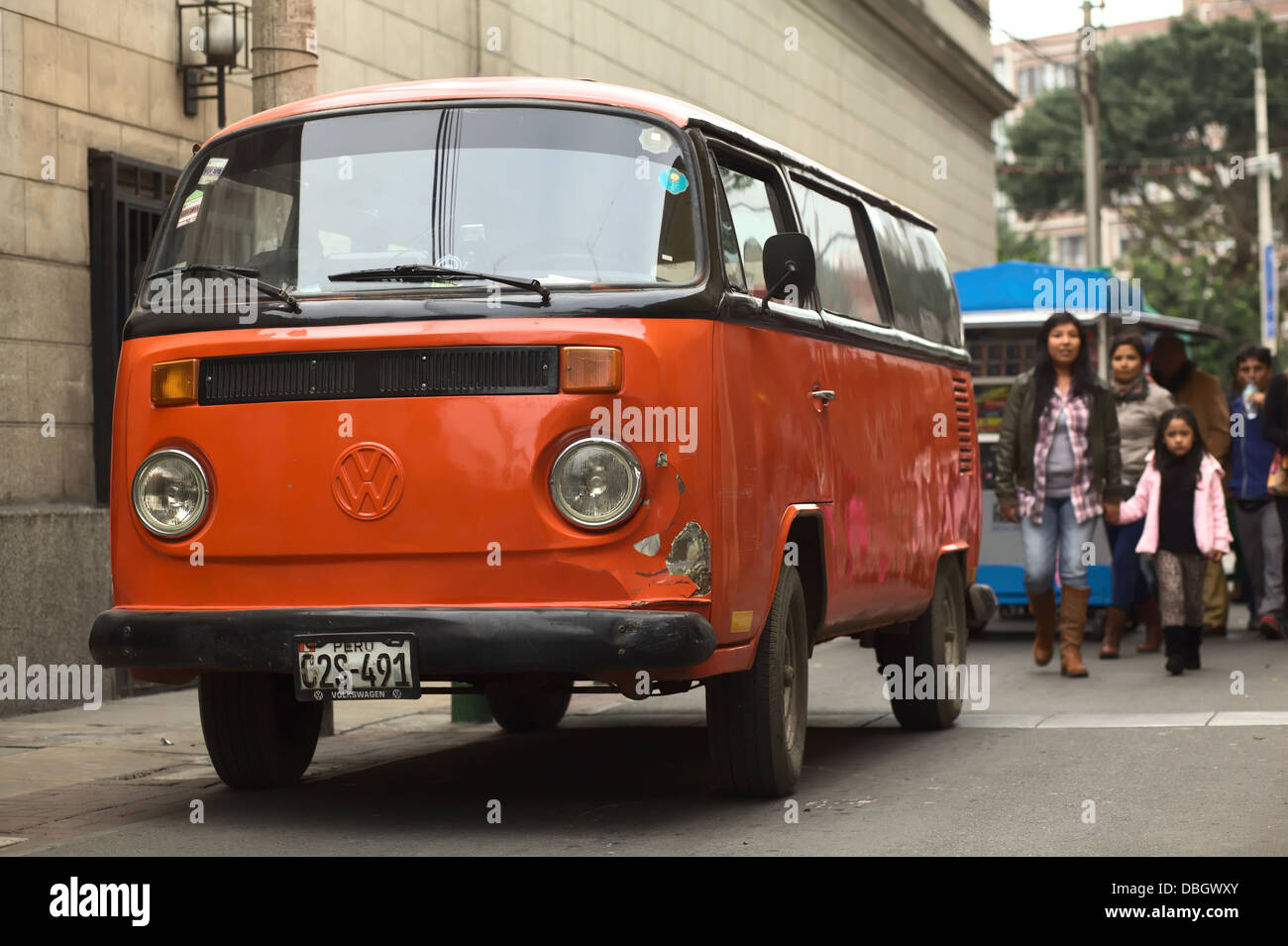 Il vecchio colore arancione Bus Volkswagen in una piccola strada del quartiere di Miraflores a Lima in Perù Foto Stock