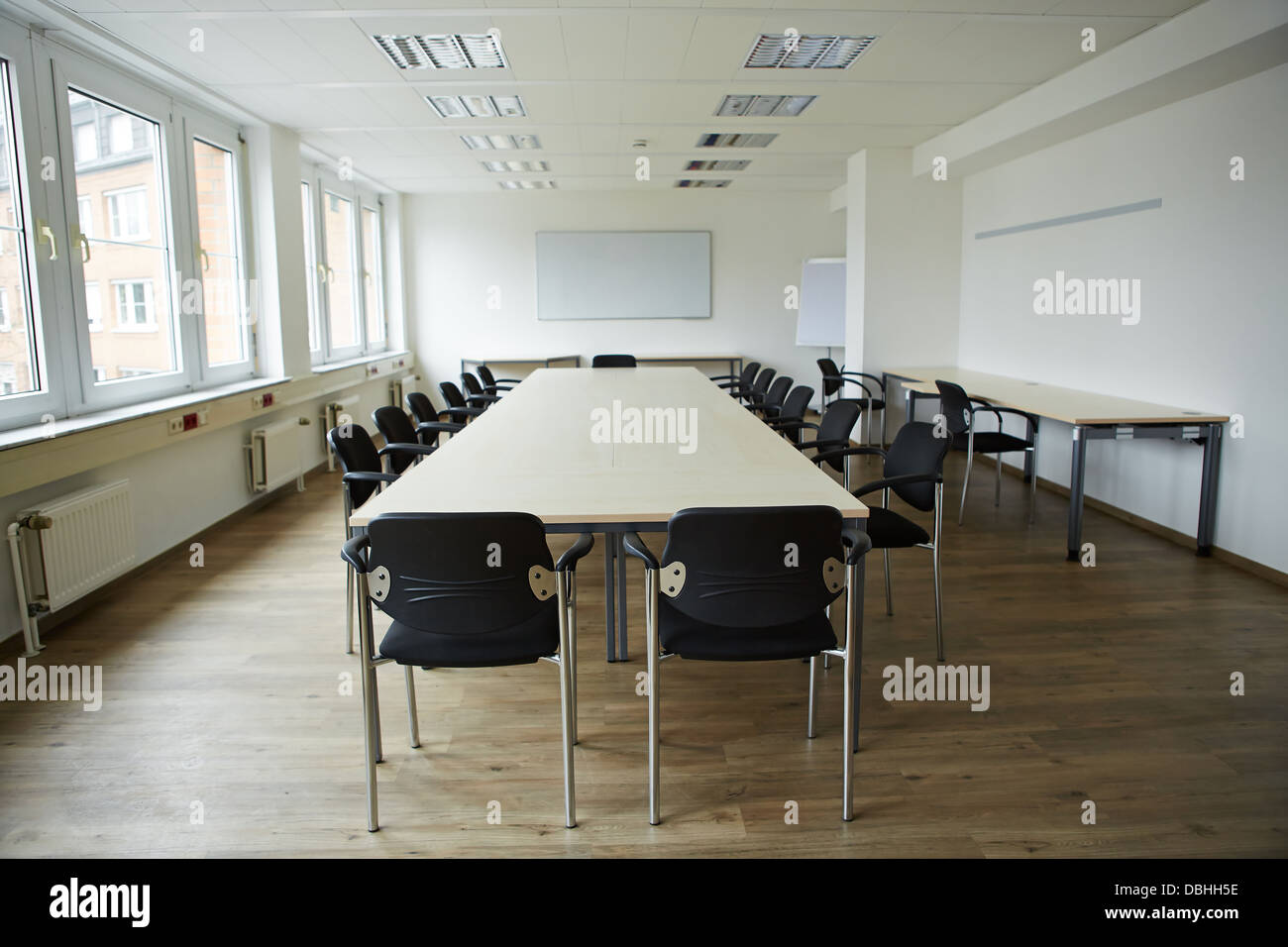 Pulire vuota sala conferenze dotata di lavagna e tavoli e sedie Foto Stock