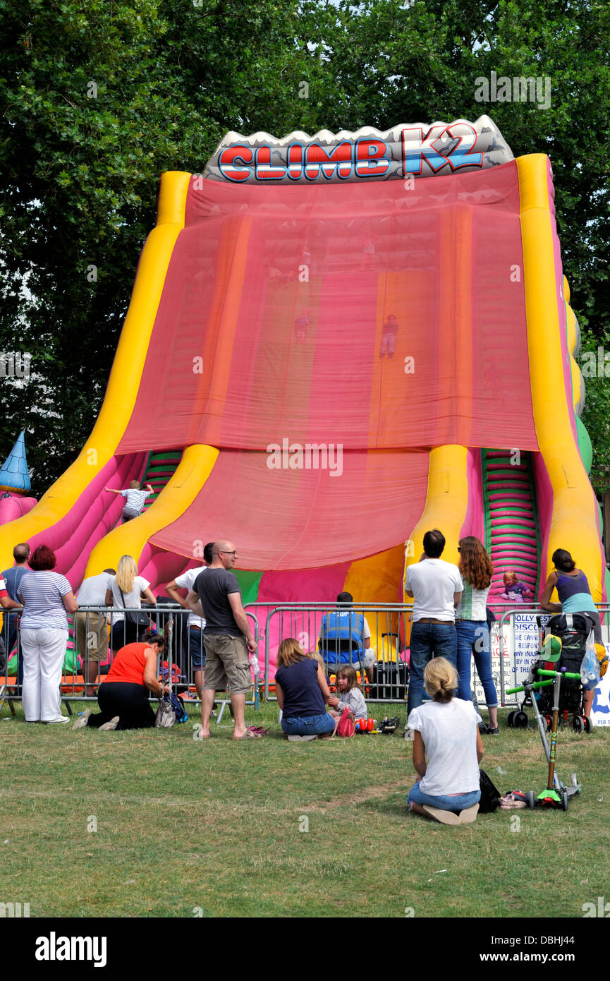 I bambini lo scorrimento verso il basso gonfiabile gigante activity slide con Sun per la protezione dello schermo net al festival di Bristol Foto Stock