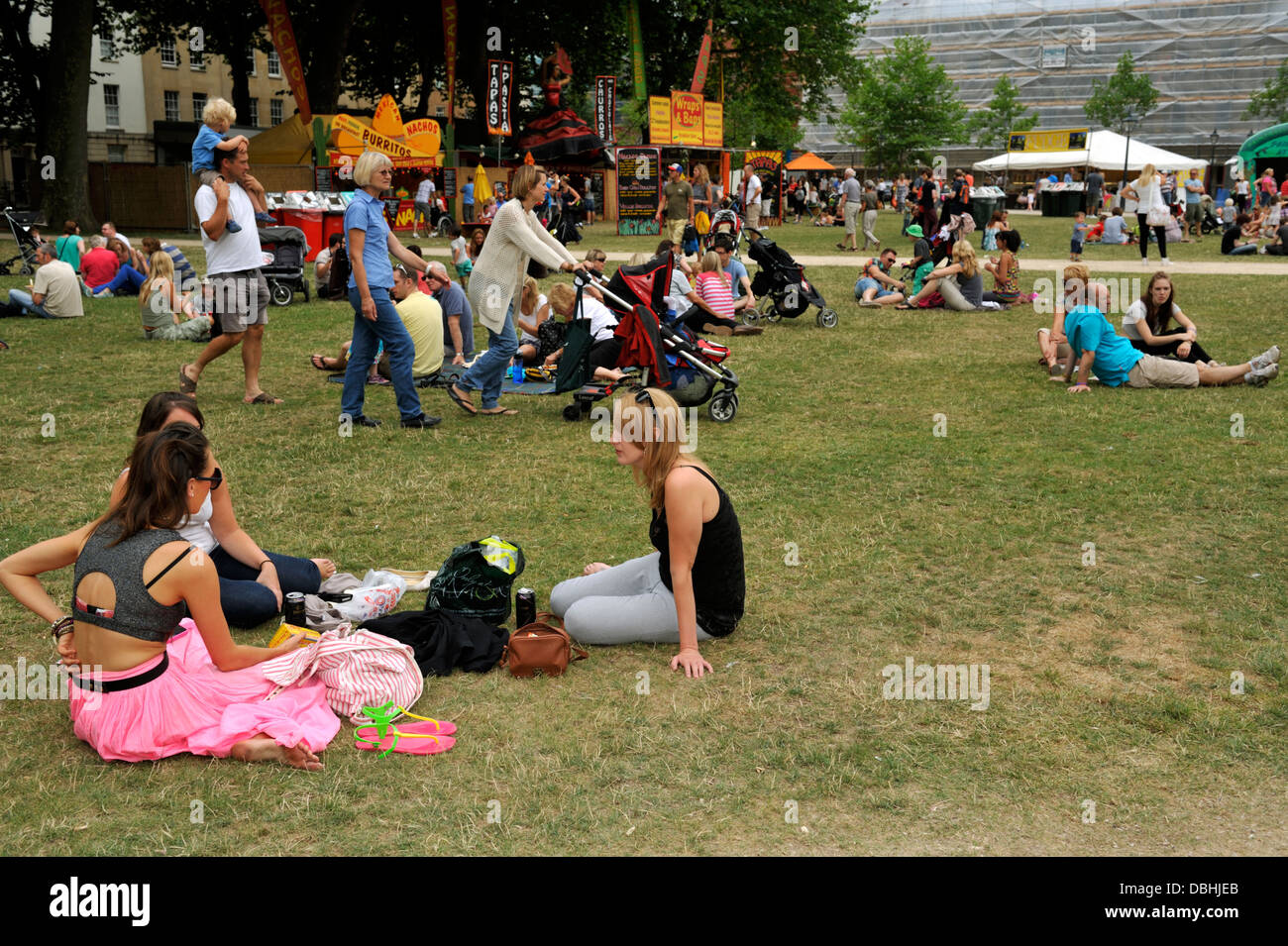 Persone relax su erba in Bristol City Queens Square park durante un festival, REGNO UNITO Foto Stock